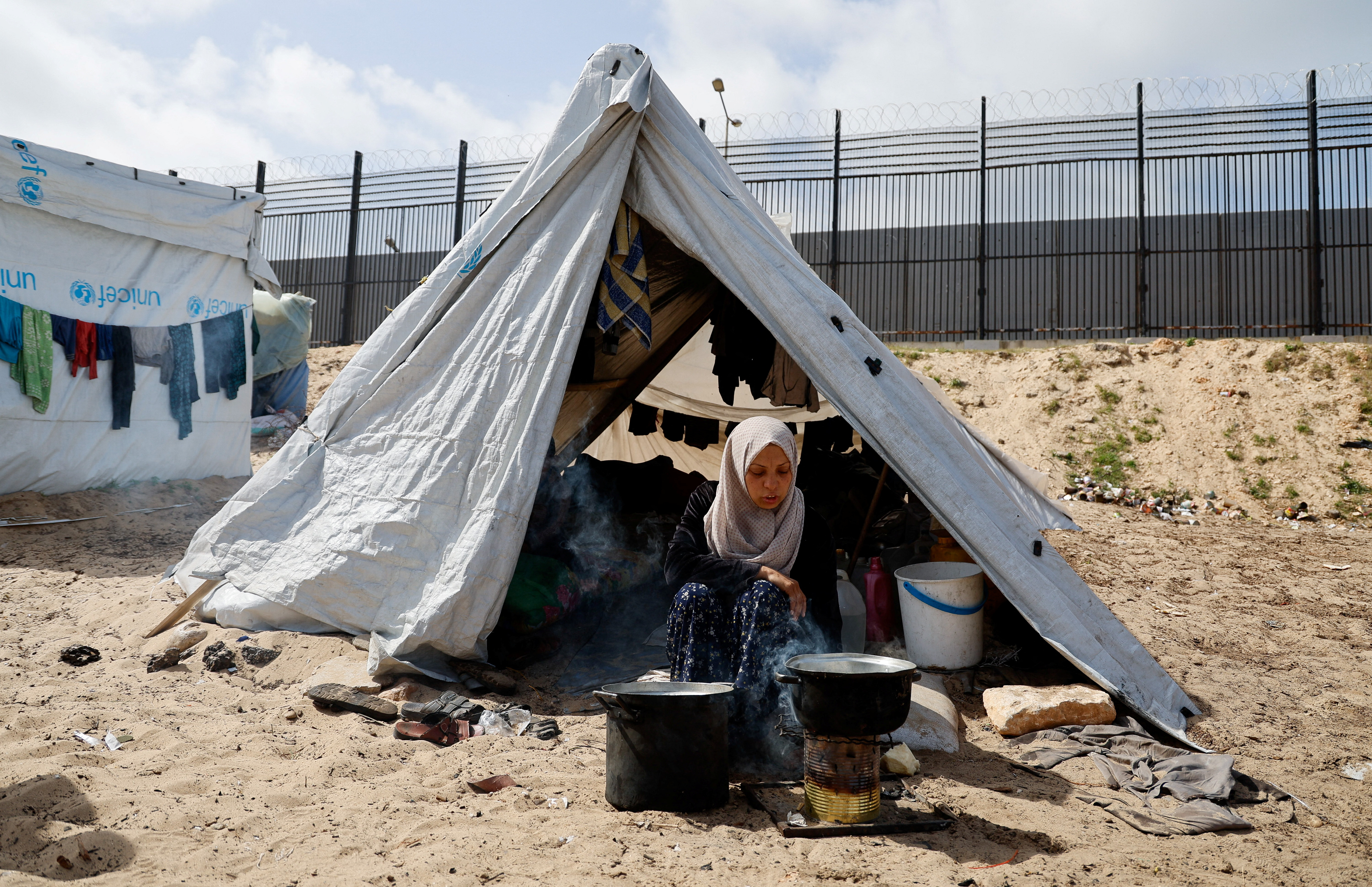 Displaced Palestinians, who fled their houses due to Israeli strikes, shelter at a tent camp, in Rafah