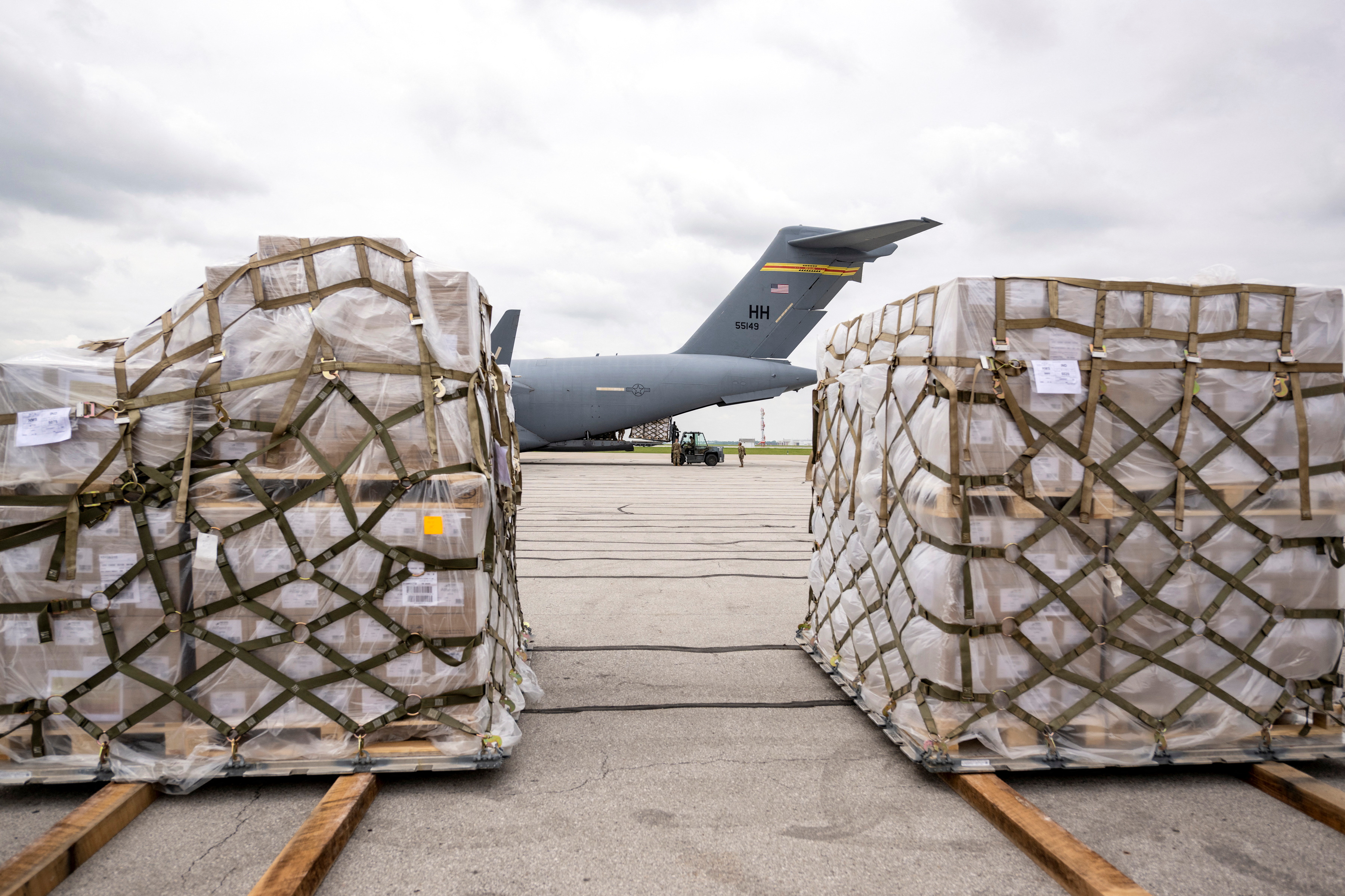 Crew members of an Air Force C-17 aircraft unload Nestle baby formula after its arrival from Ramstein Air Base