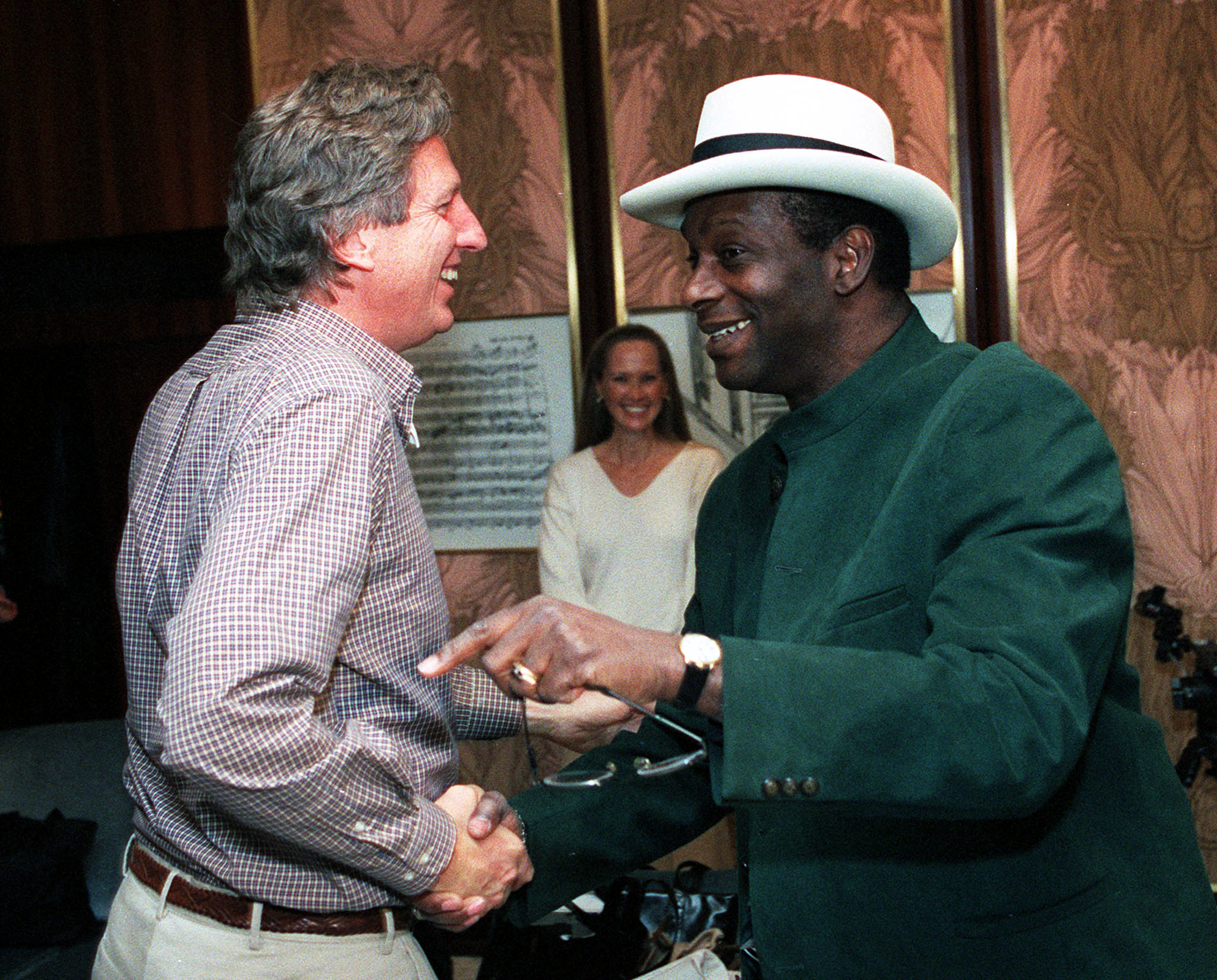 U.S. sports legends Dick Fosbury (L) and Bob Beamon shake hands after arriving at Vienna's airport N..