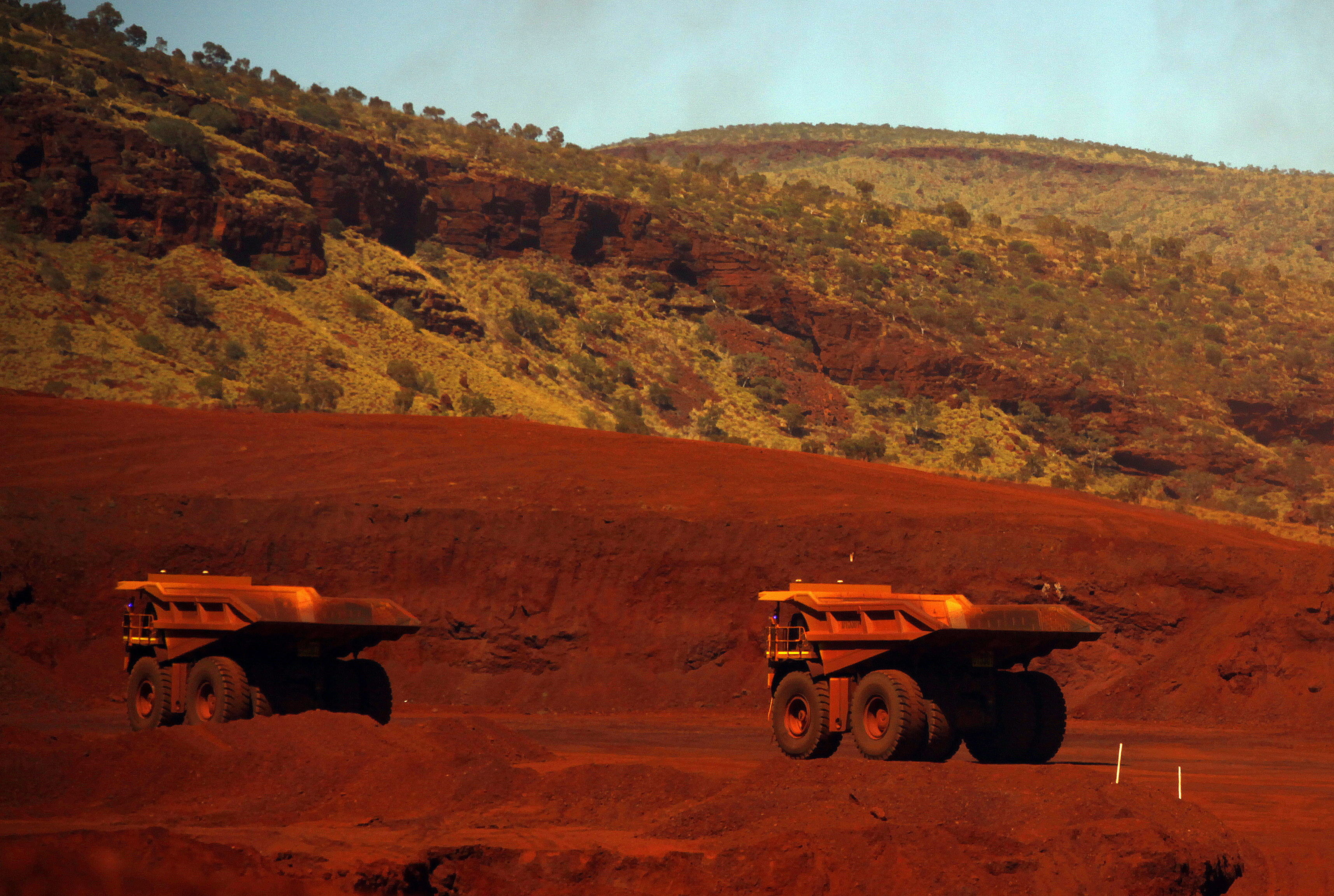 Trucks wait to be loaded with iron ore at the Fortescue Solomon iron ore mine located in the Valley of the Kings