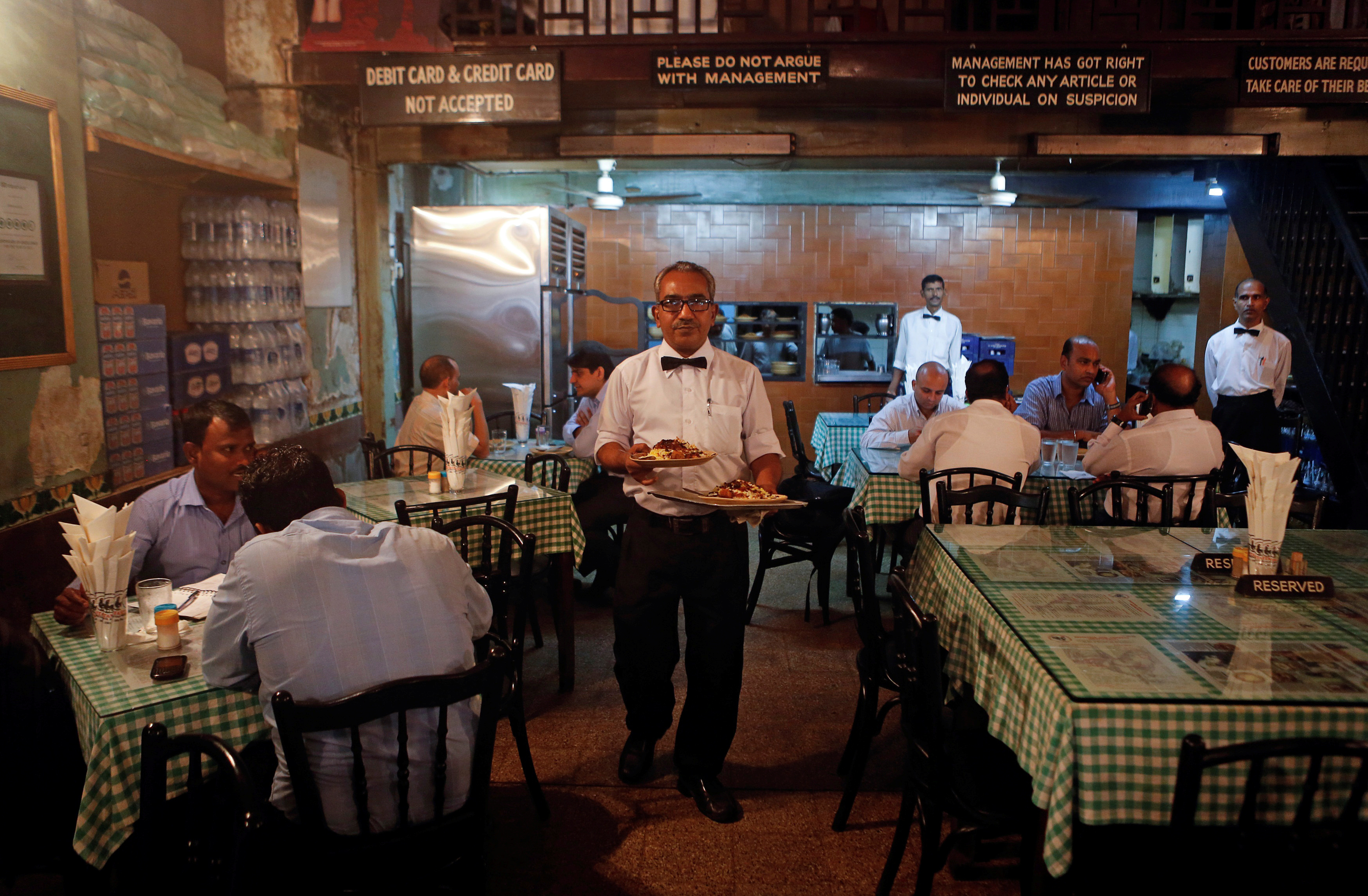 Waiter carries plates of food for customers at the Britannia and Co. restaurant in Mumbai