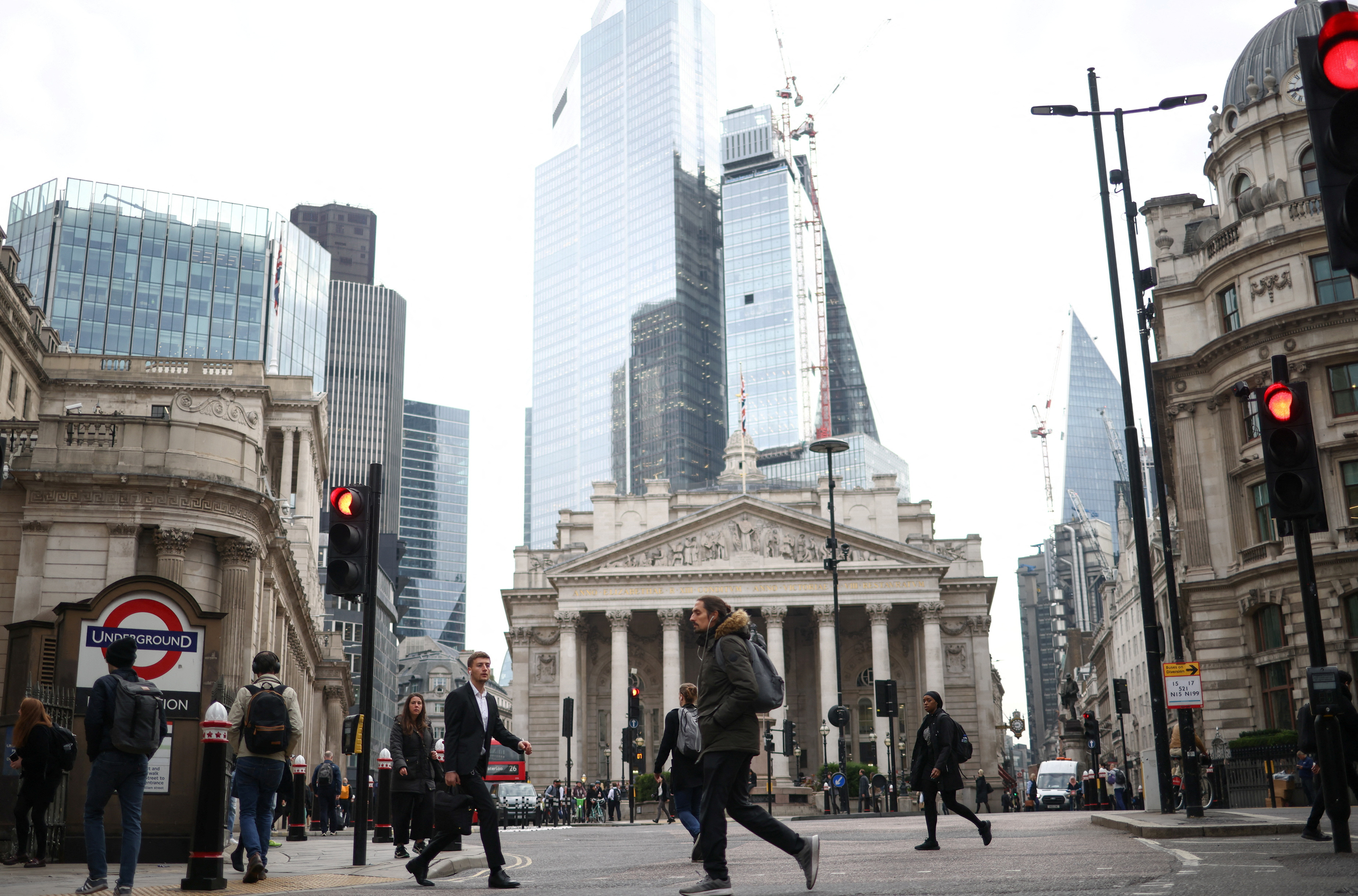 People walk through the City of London financial district during rush hour in London