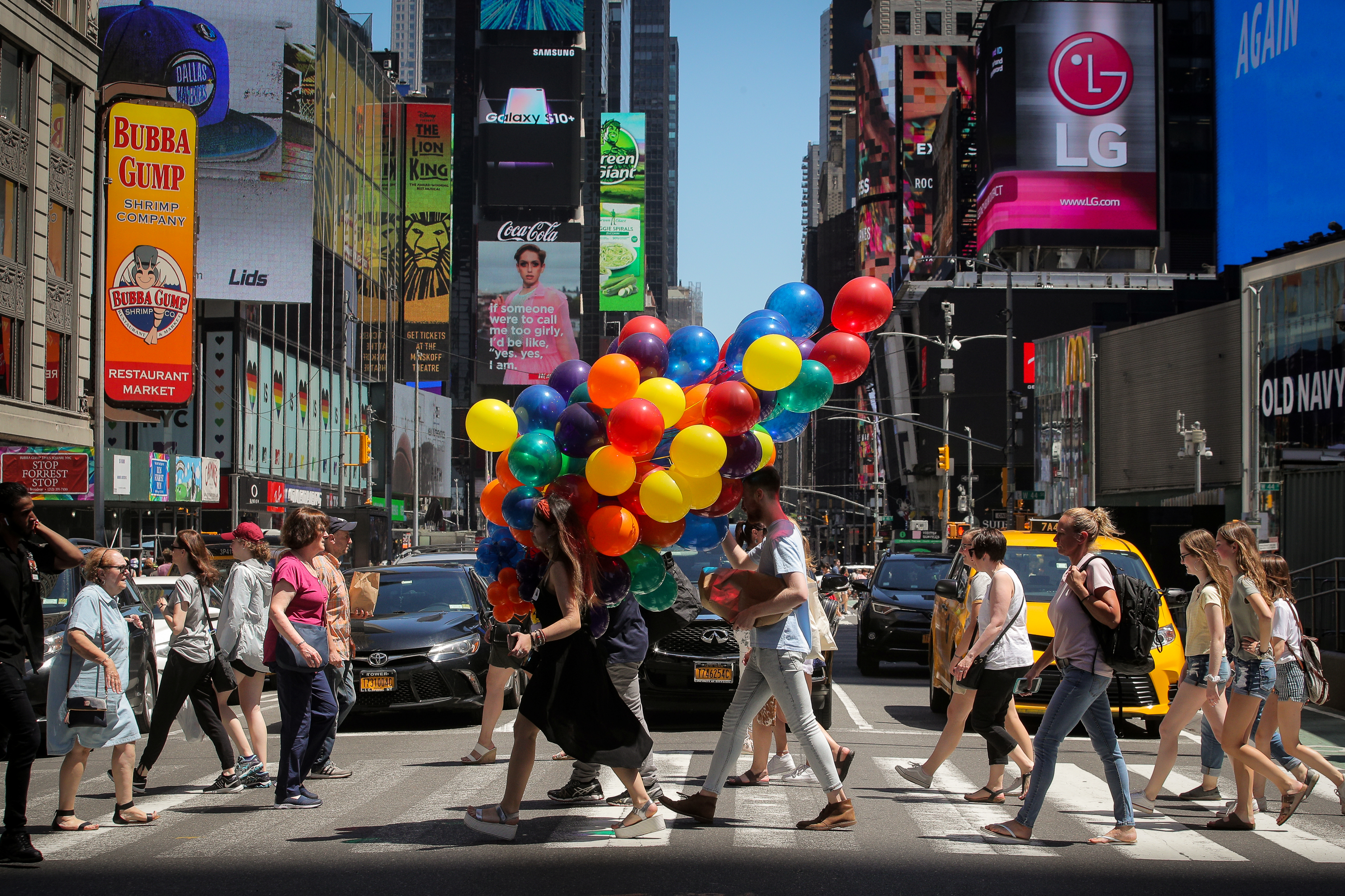 A woman carries a bunch of balloons through Times Square in New York