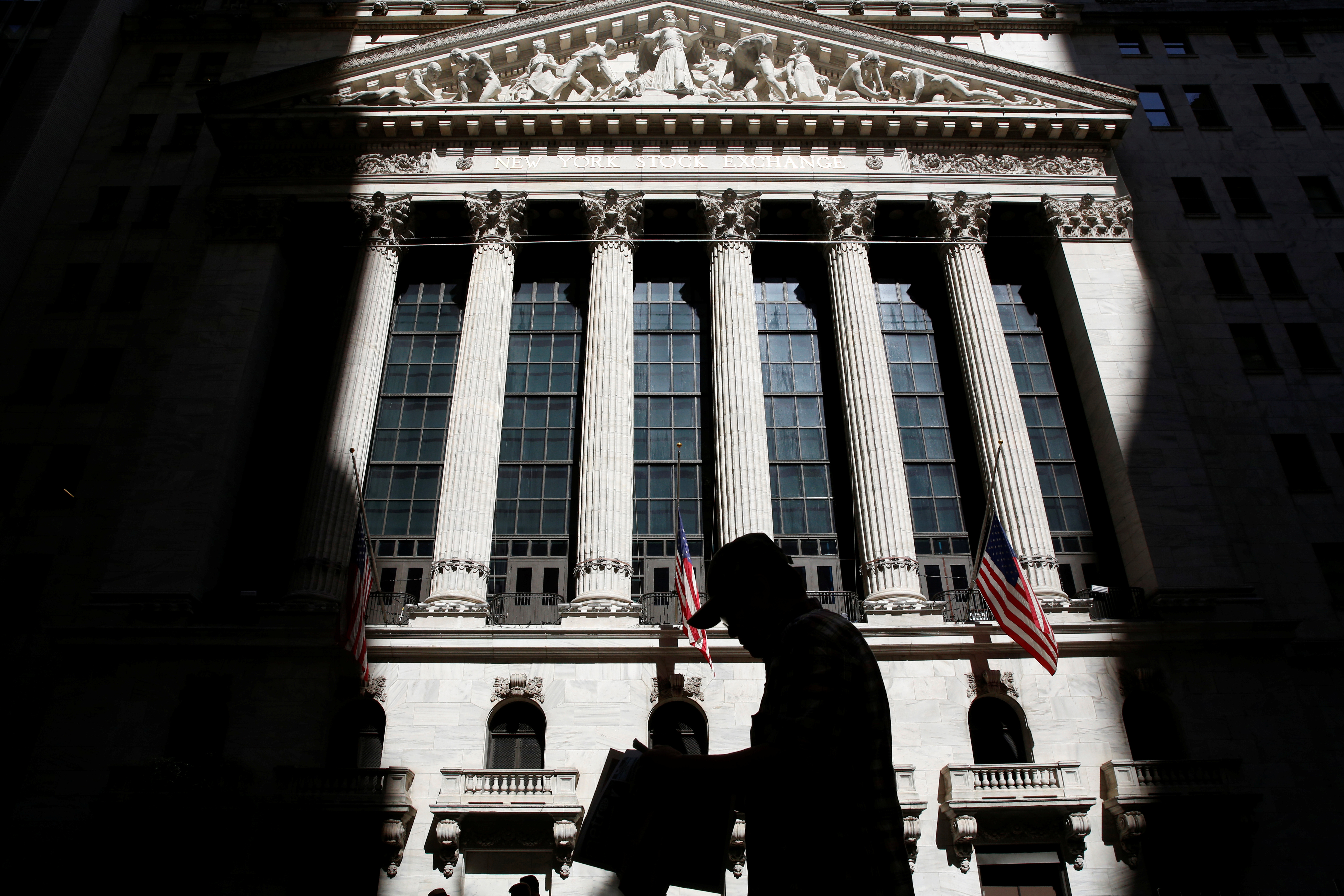 A man passes by the New York Stock Exchange (NYSE) in New York City