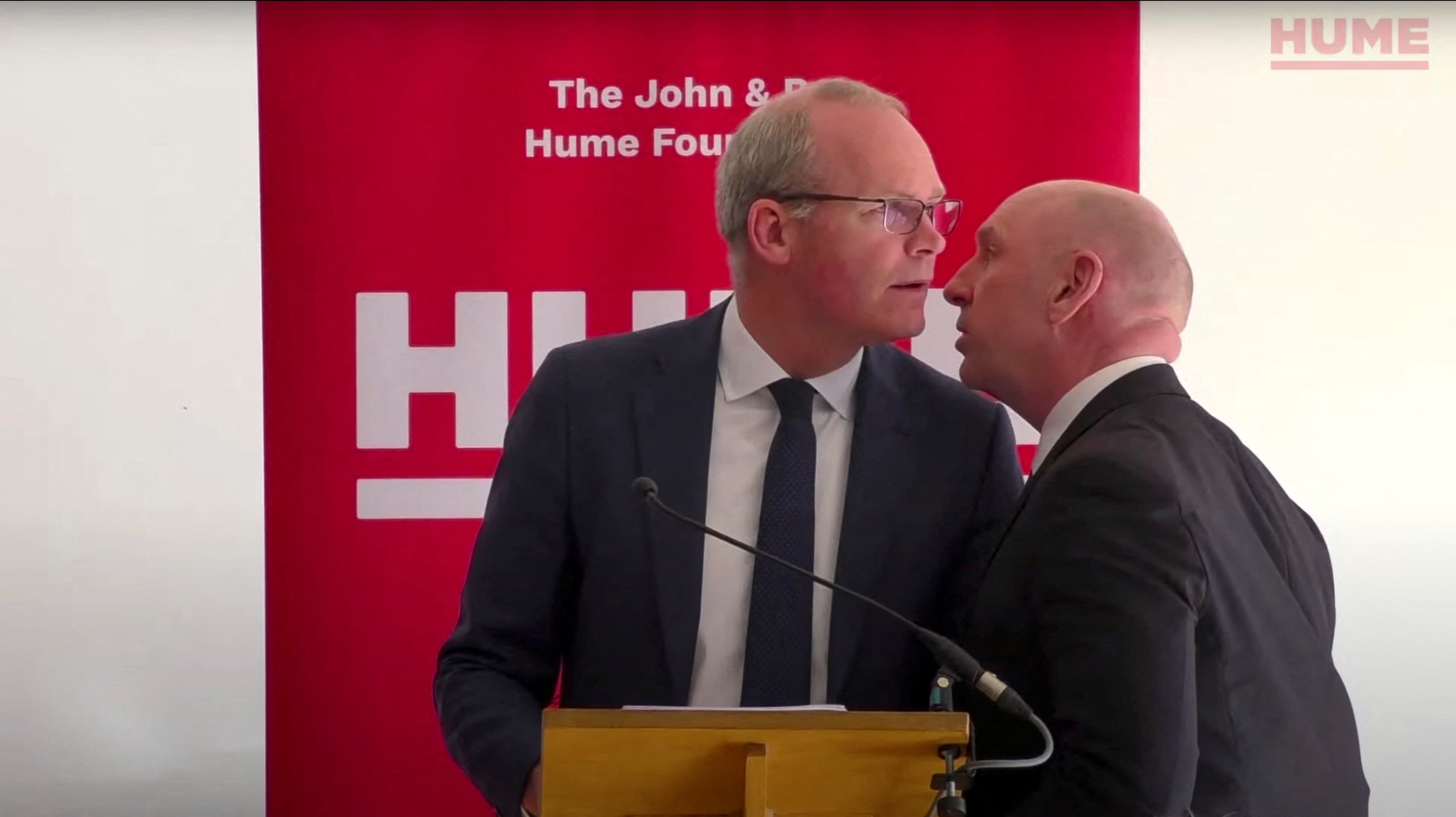 Irish Foreign Minister Simon Coveney learns about a potential security threat during his speech at an event of the The John And Pat Hume Foundation in Belfast