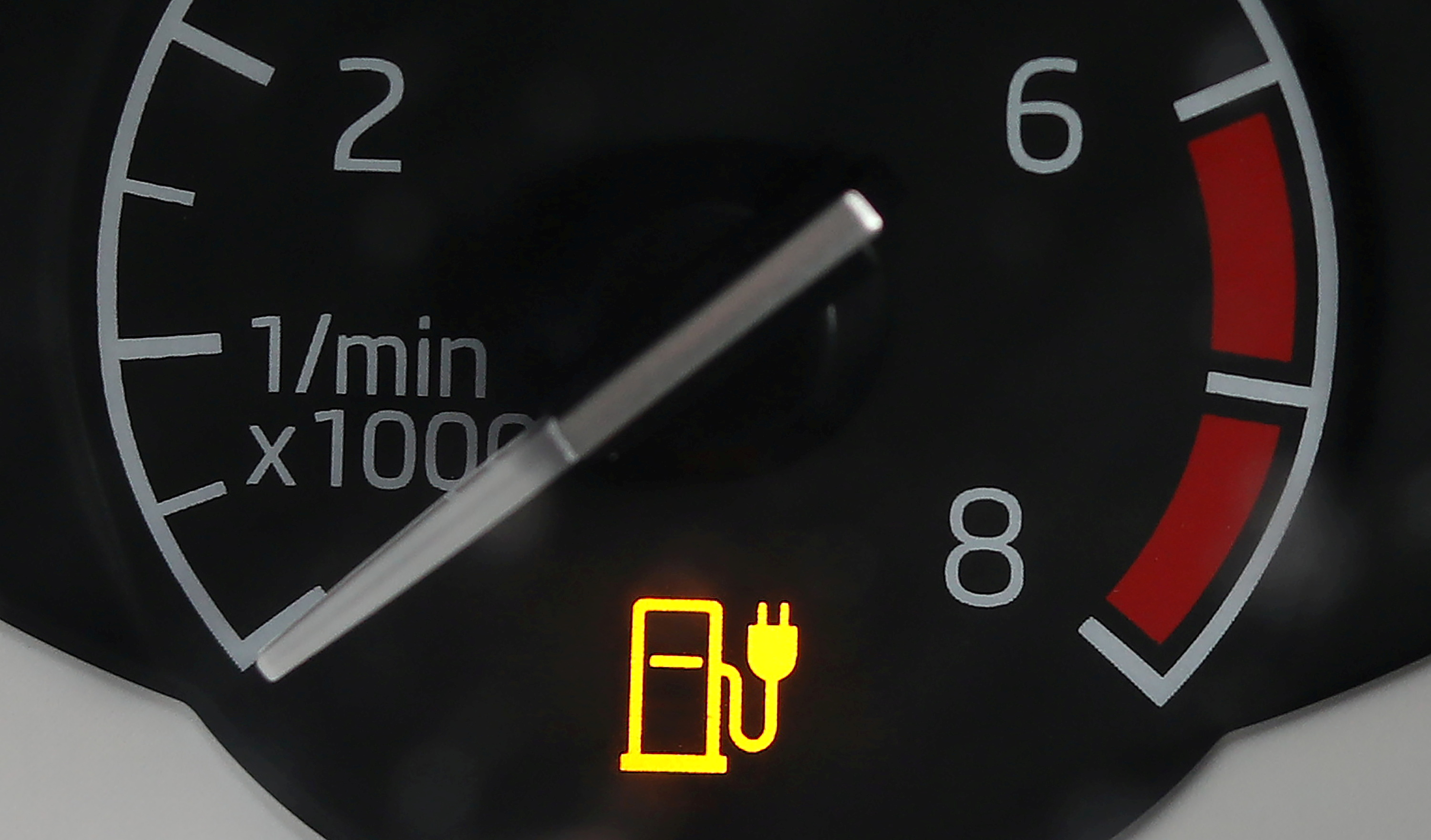 An electricity charging indicator is seen on the dashboard of a Plug-in hybrid electric car outside a house in Manchester