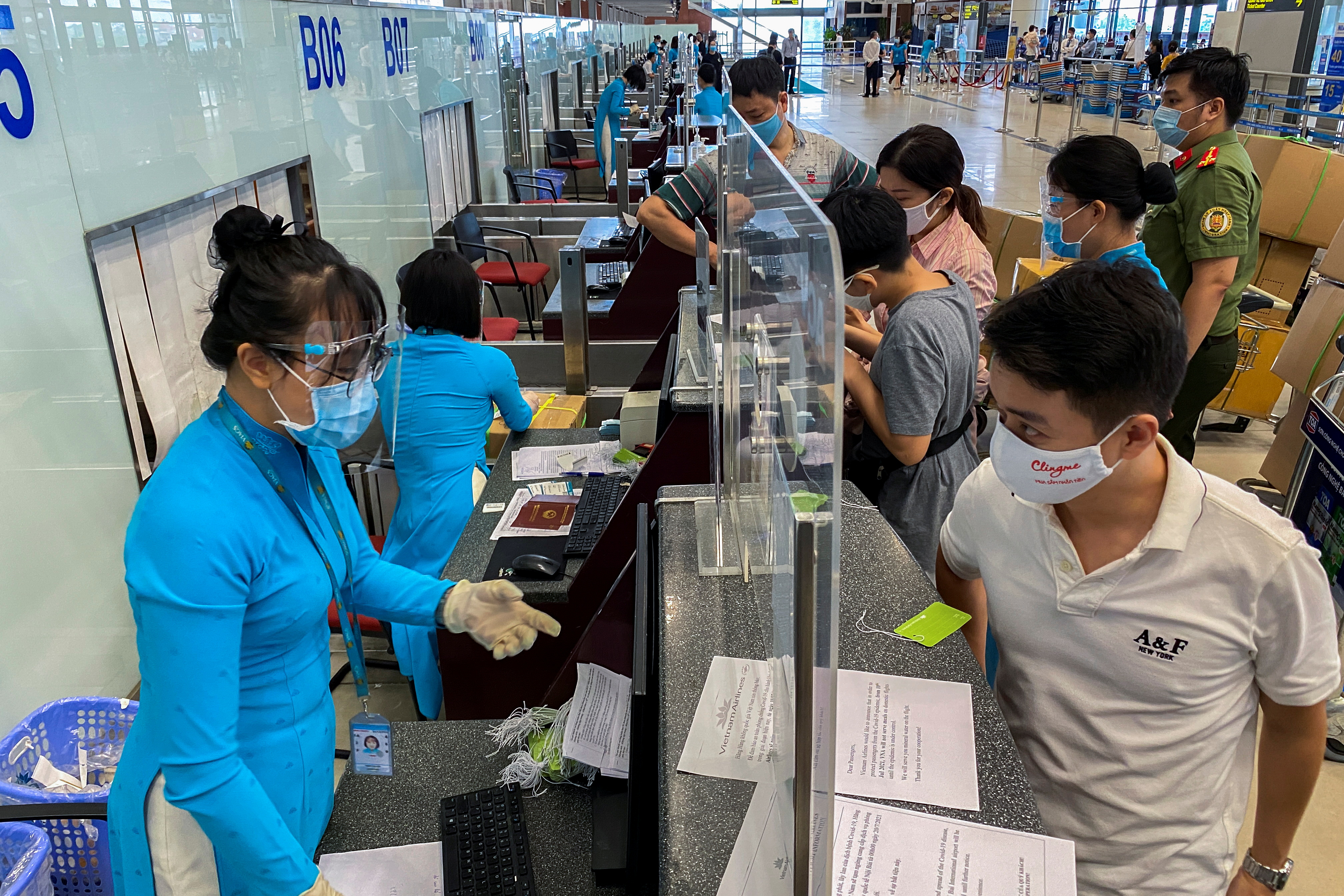 Passengers wearing protective face masks check-in at Noi Bai International Airport, as the Vietnamese government has allowed reopening several domestic air routes amid the coronavirus disease (COVID-19) pandemic, in Hanoi, Vietnam, October 10, 2021. Picture taken October 10, 2021. REUTERS/Nguyen Thinh Tien/File Photo