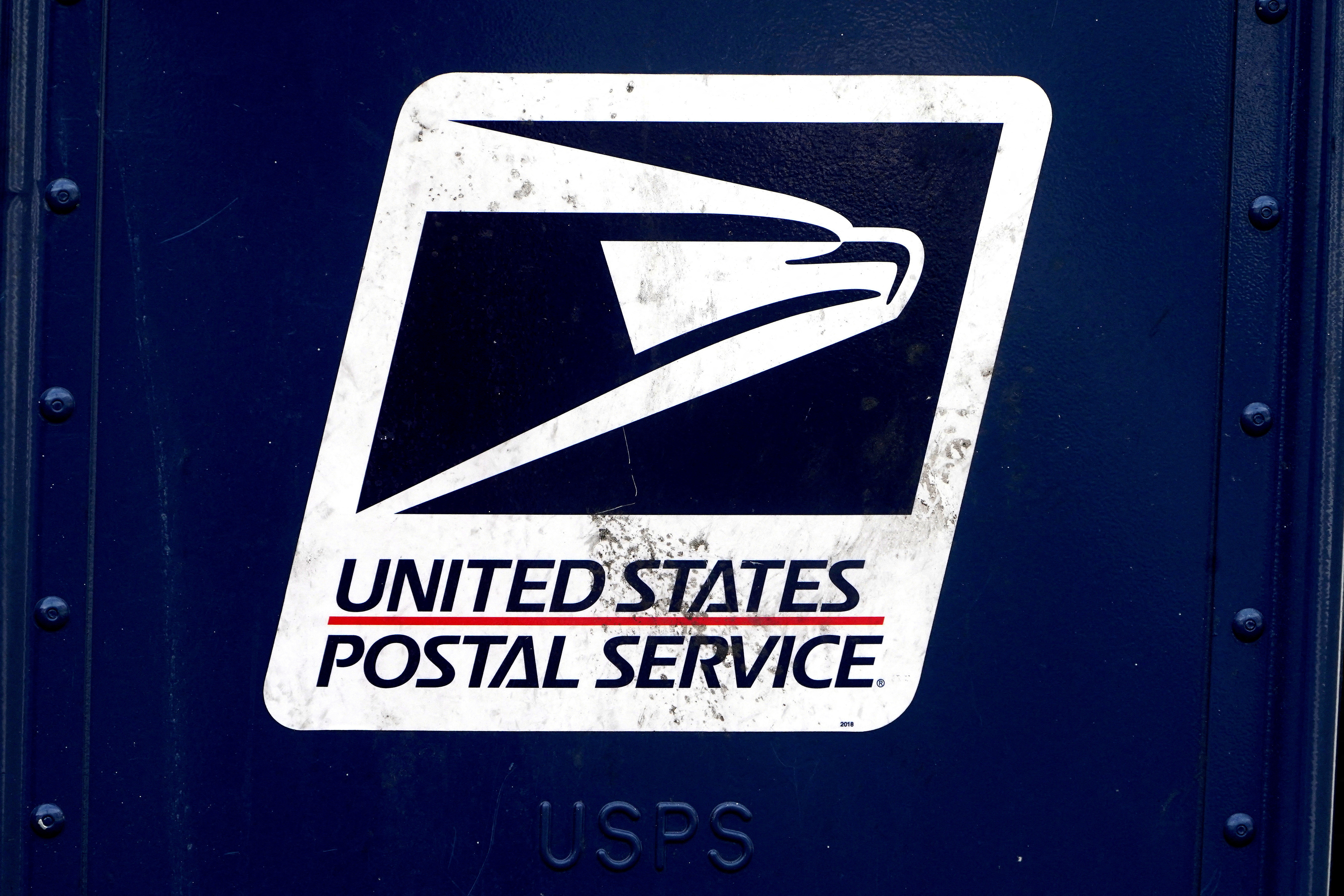 A U.S. Postal Service (USPS) logo is pictured on a mail box