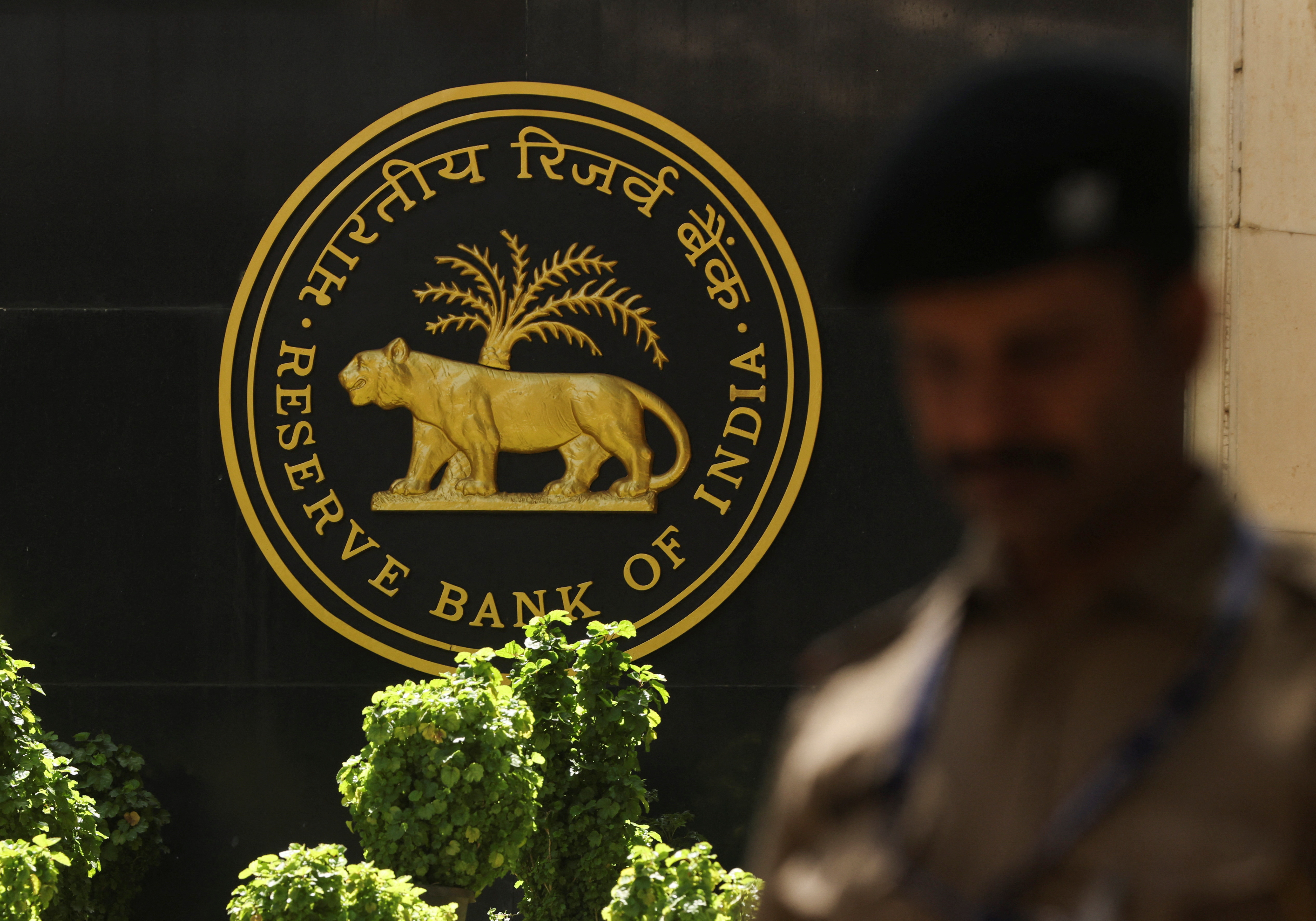 A police officer walks past the Reserve Bank of India (RBI) logo inside its headquarters in Mumbai