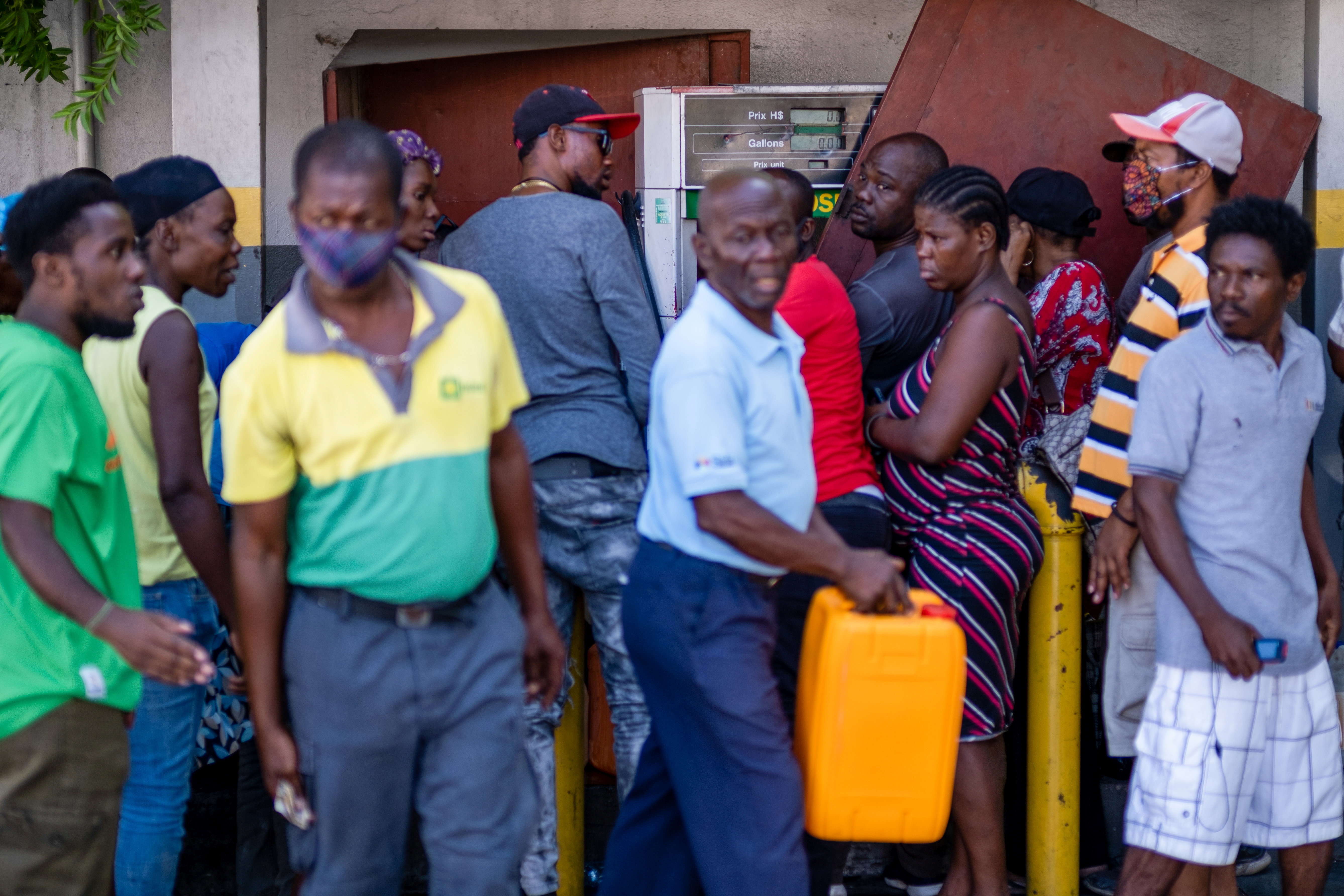 People line-up at a gasoline station to buy gas following the assassination of President Jovenel Moise, in Port-au-Prince