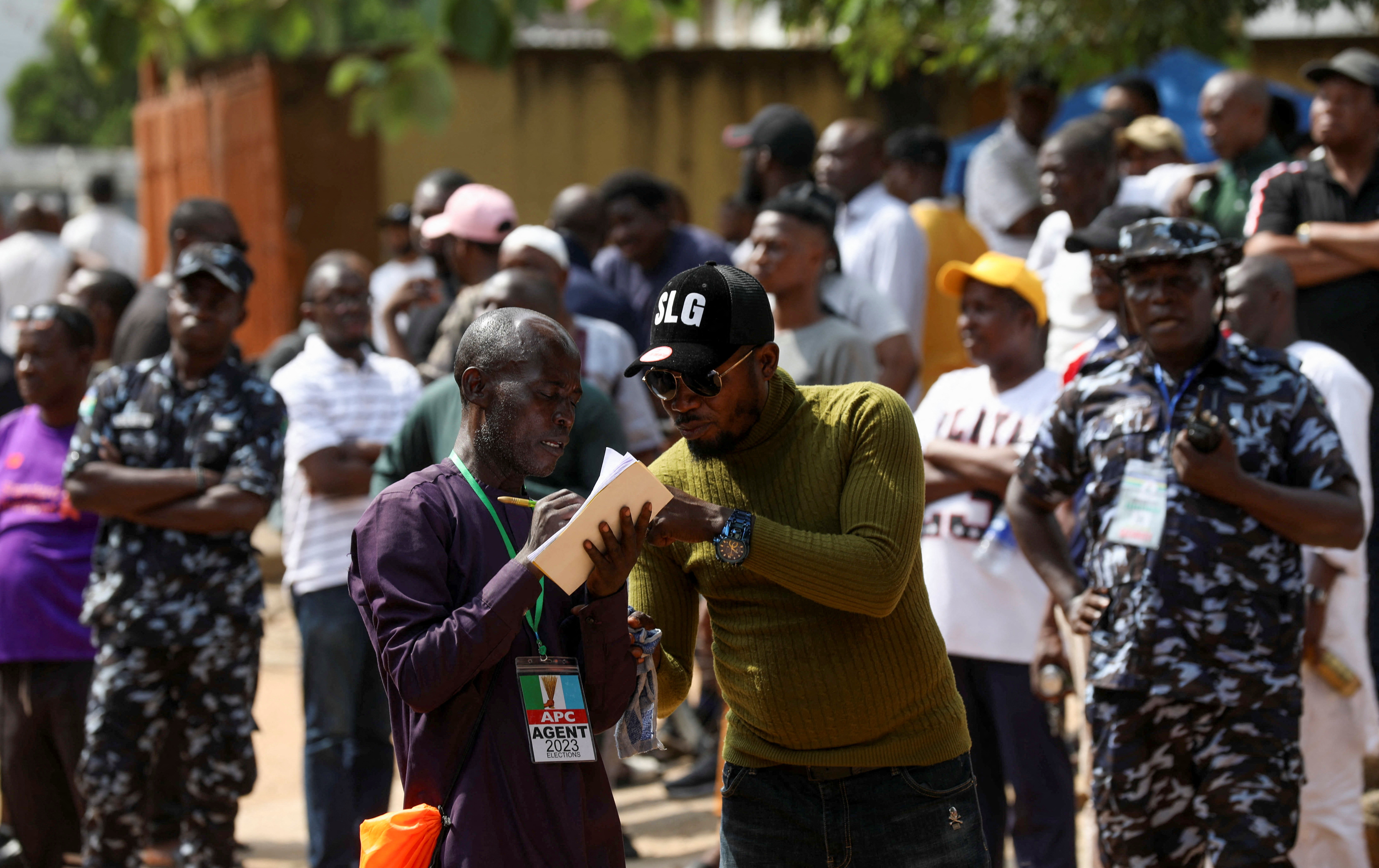 Political party agents discuss results after the vote-counting process at a polling unit, in Lagos