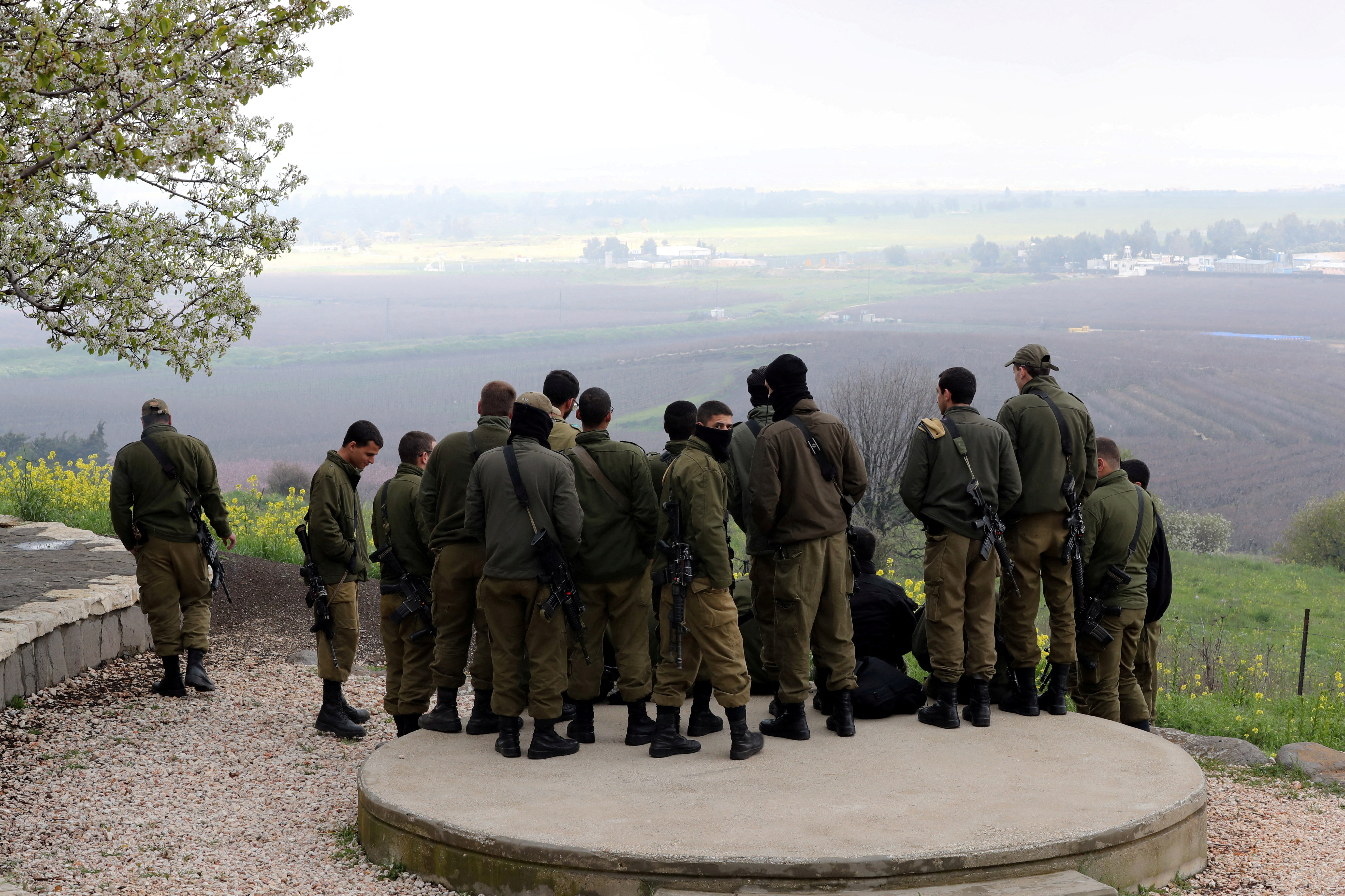 Israeli soldiers stand together at a lookout point near the ceasefire line between Israel and Syria in the Israeli-occupied Golan Heights