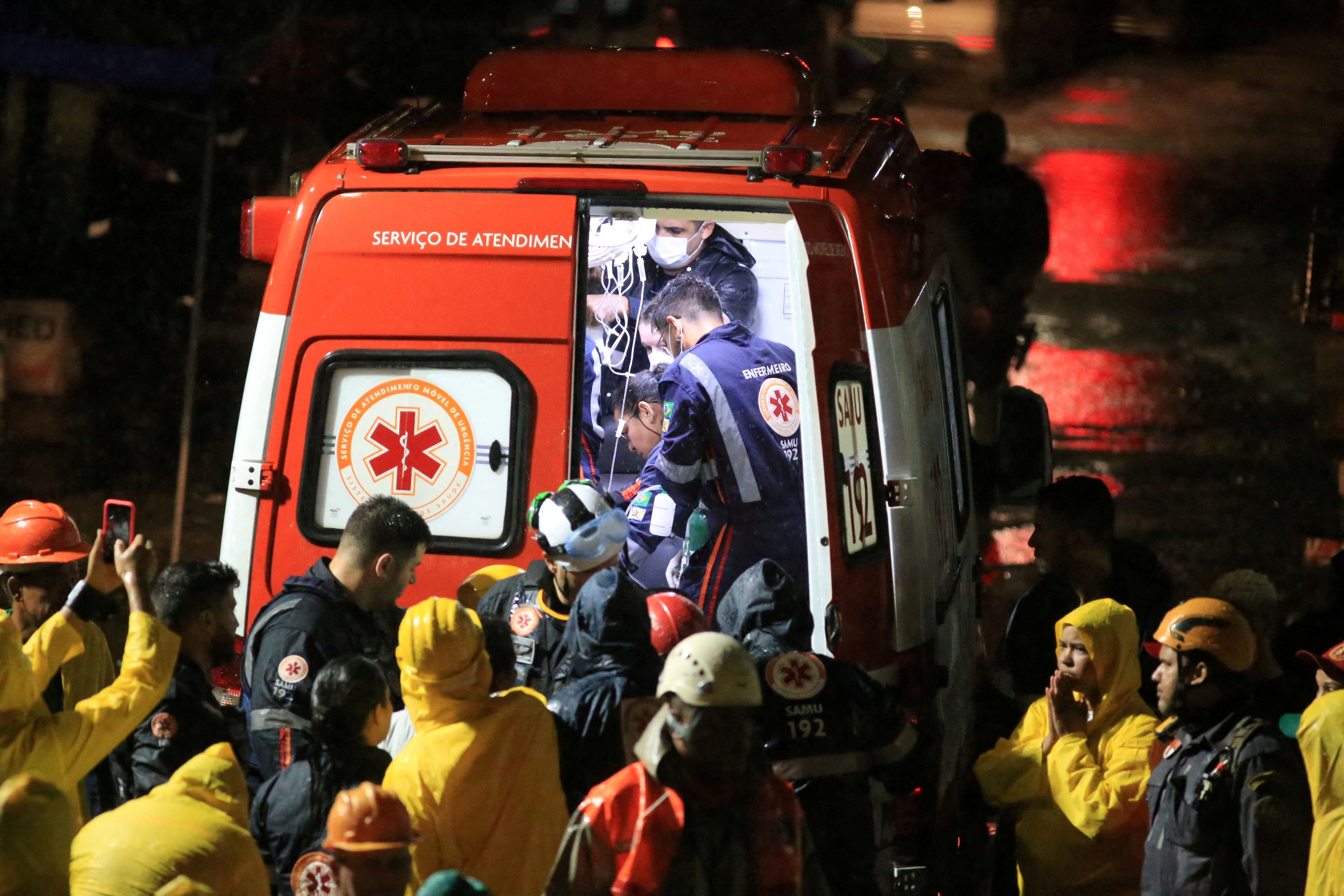 Rescue workers carry an injured person found among debris after a building collapsed in Recife, Pe ambuco state