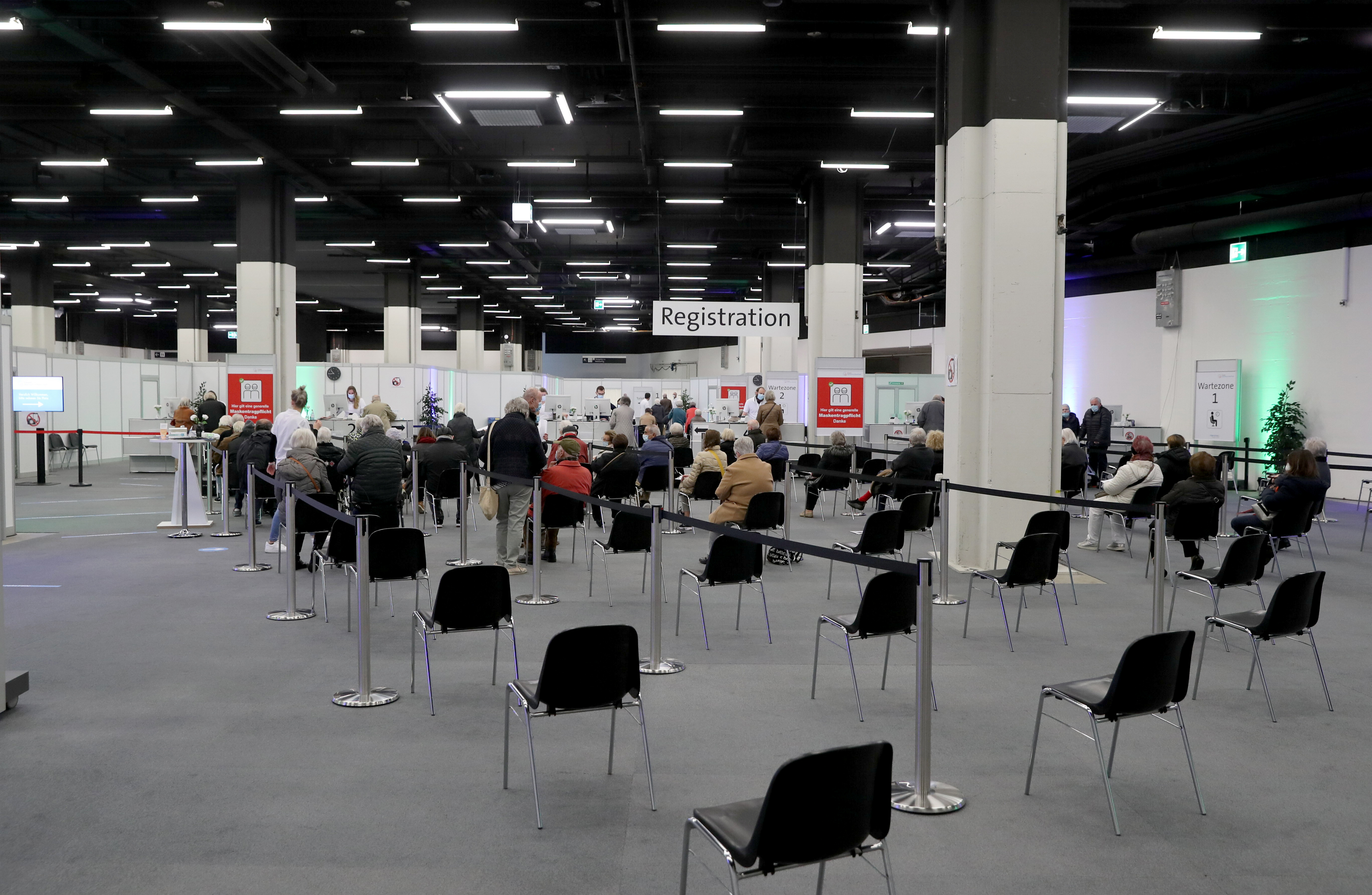 People wait at the Impfzentrum Basel Stadt vaccination center at the Congress Center in Basel