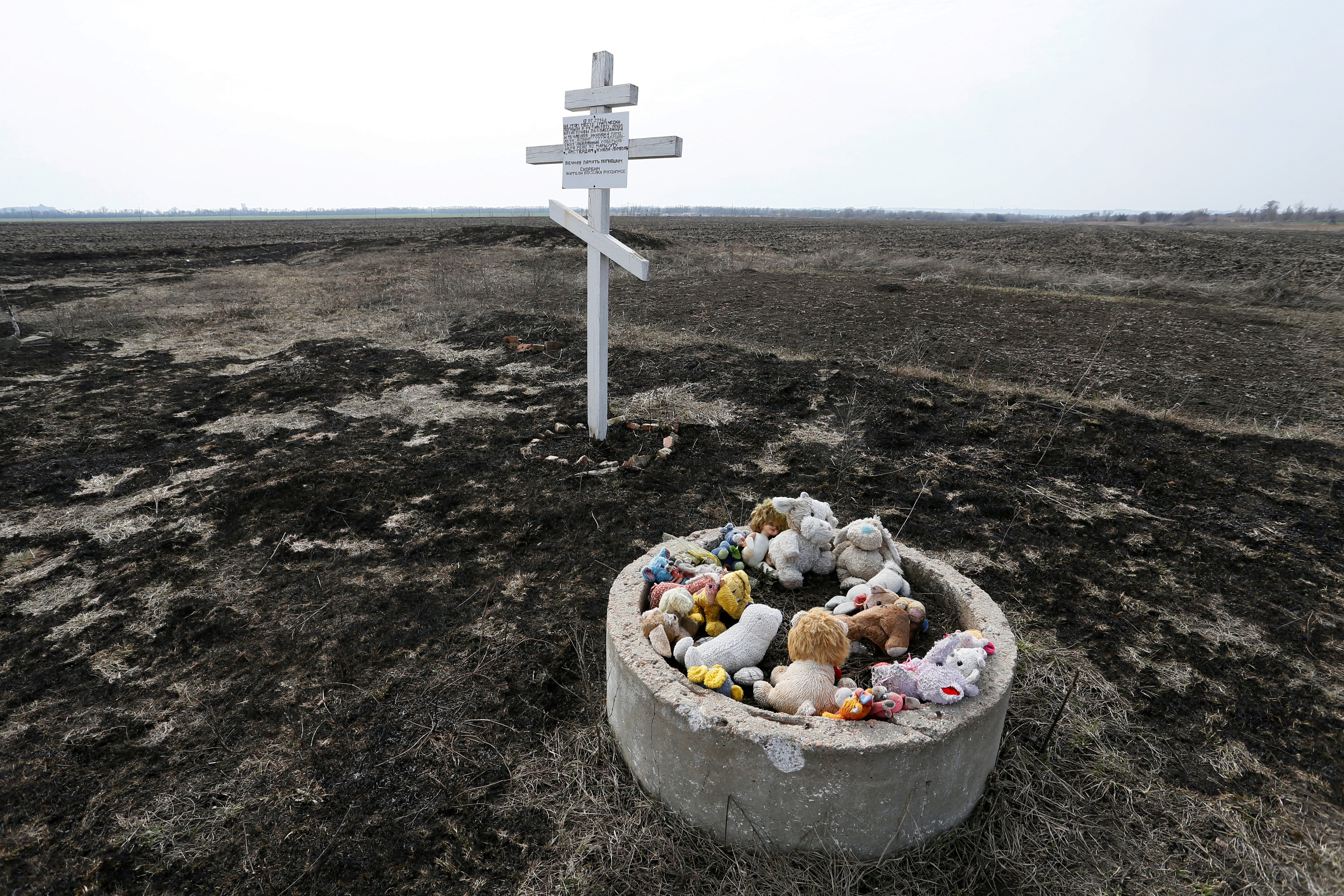 Toys are placed near the cross in memory of victims of Malaysia Airlines Flight MH17 plane crash in Rozsypne