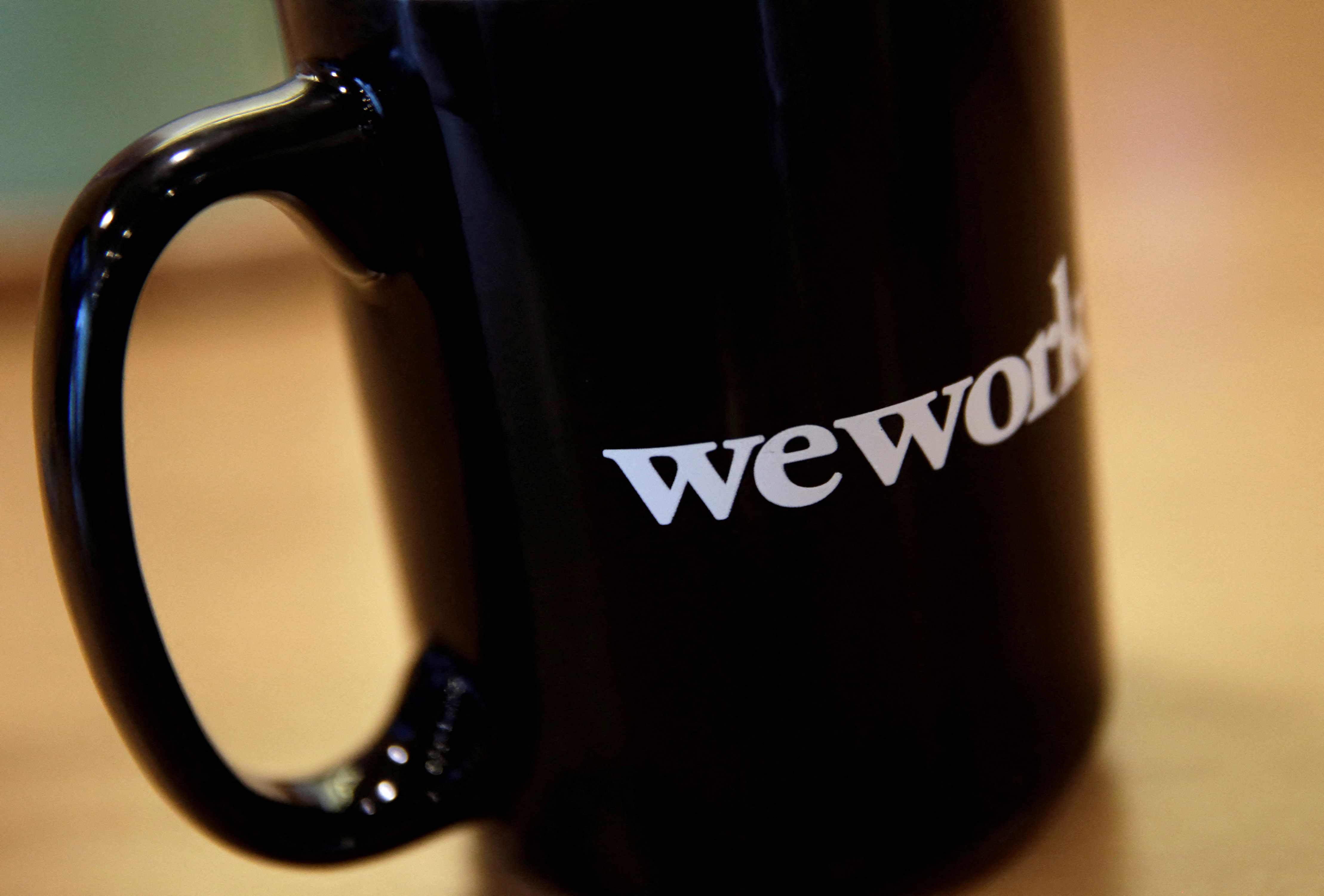The WeWork logo is seen on a cup at a WeWork office in Beijing