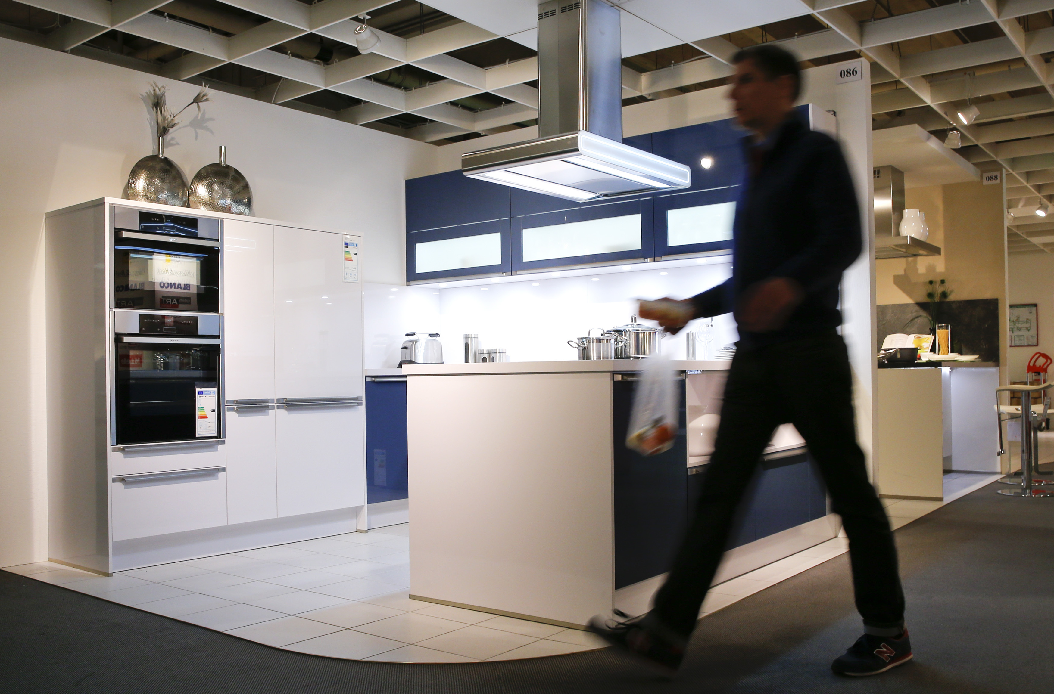 A man walks past at a kitchen by German kitchen maker Haecker inside a furniture shop in Berlin