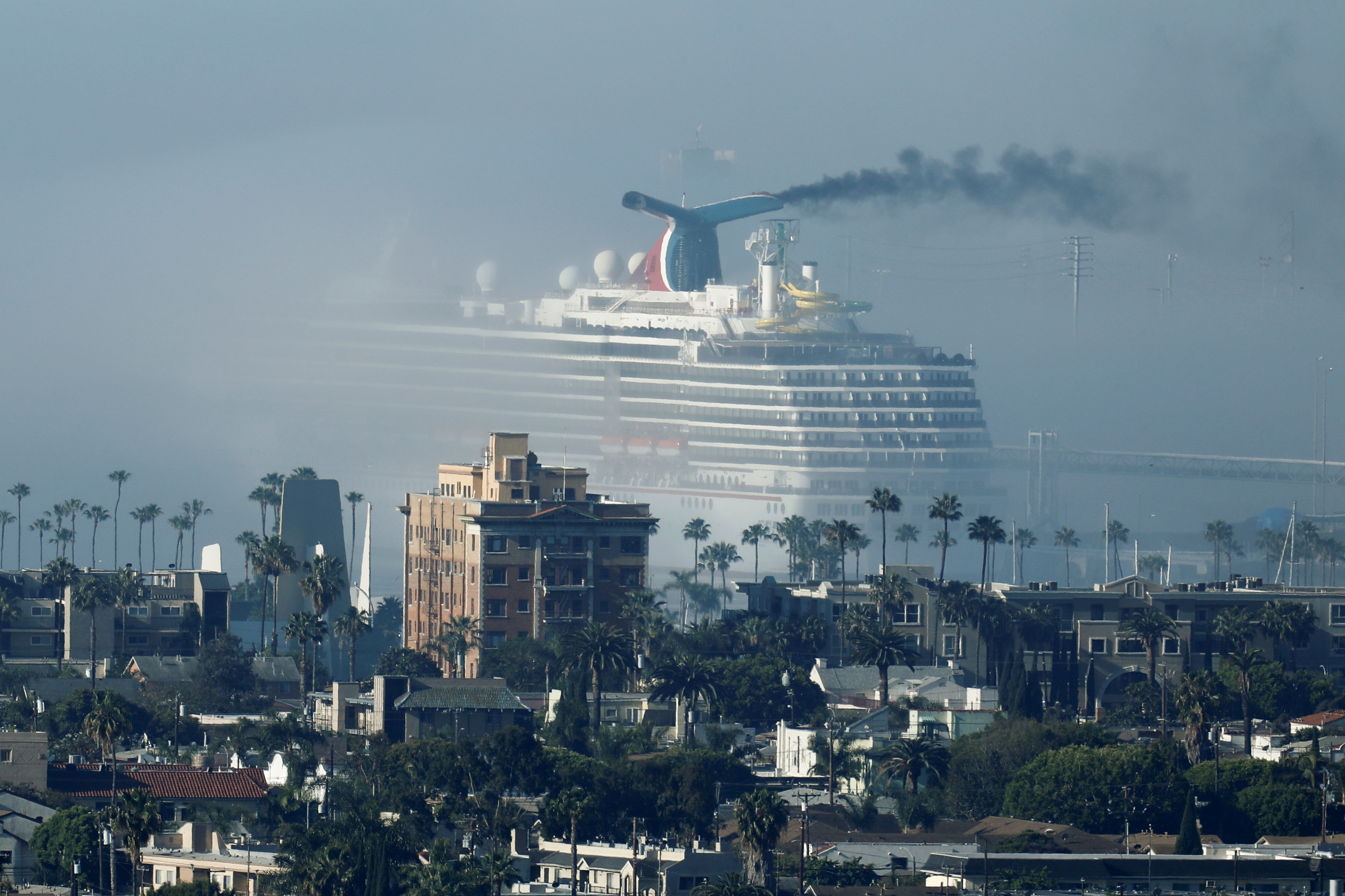 The cruise ship Carnival Miracle sits in fog at the port of the Long Beach, California