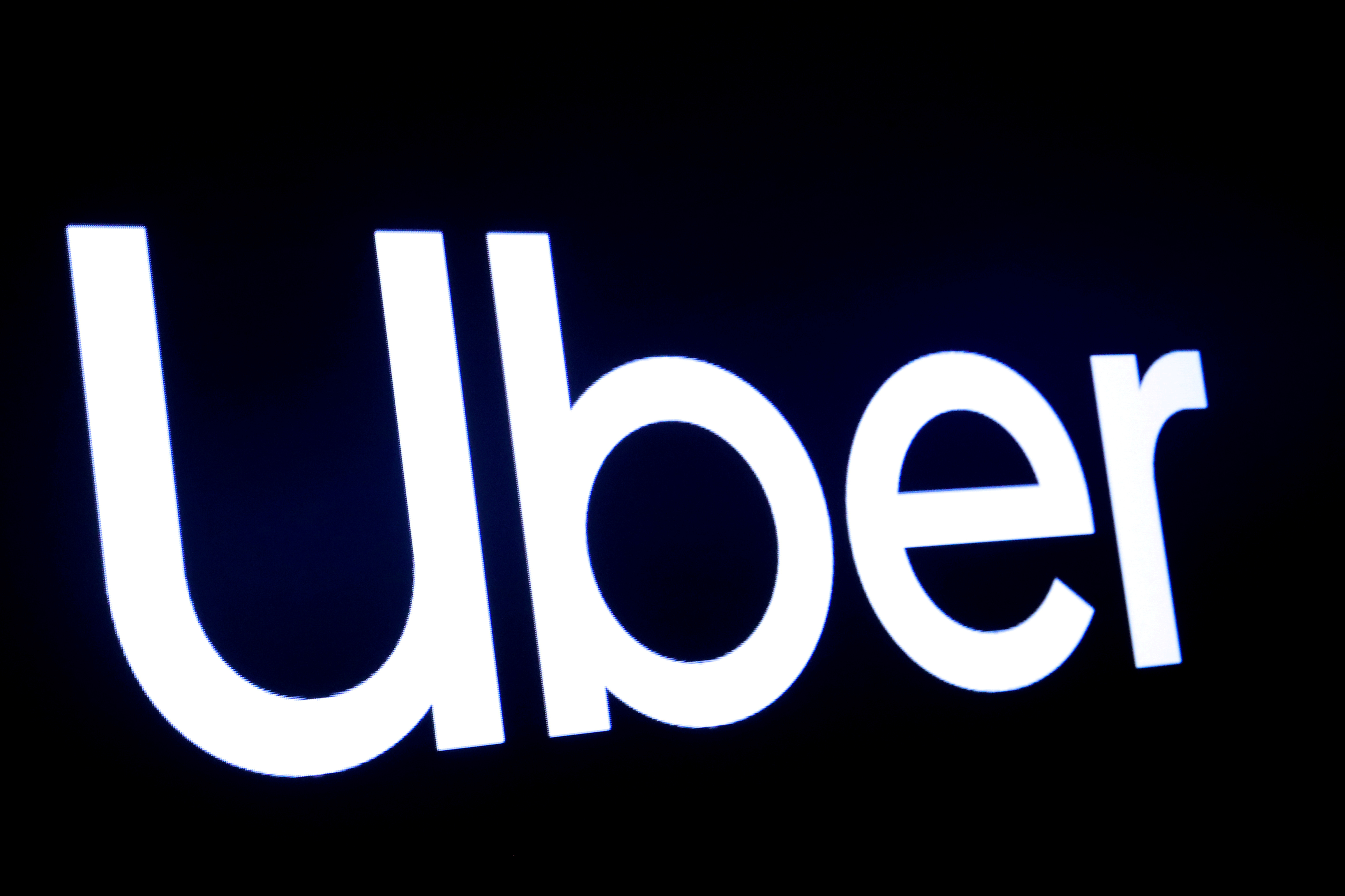 A screen displays the company logo for Uber Technologies Inc at the New York Stock Exchange (NYSE) in New York, U.S., May 10, 2019. REUTERS/Brendan McDermi/File Photo