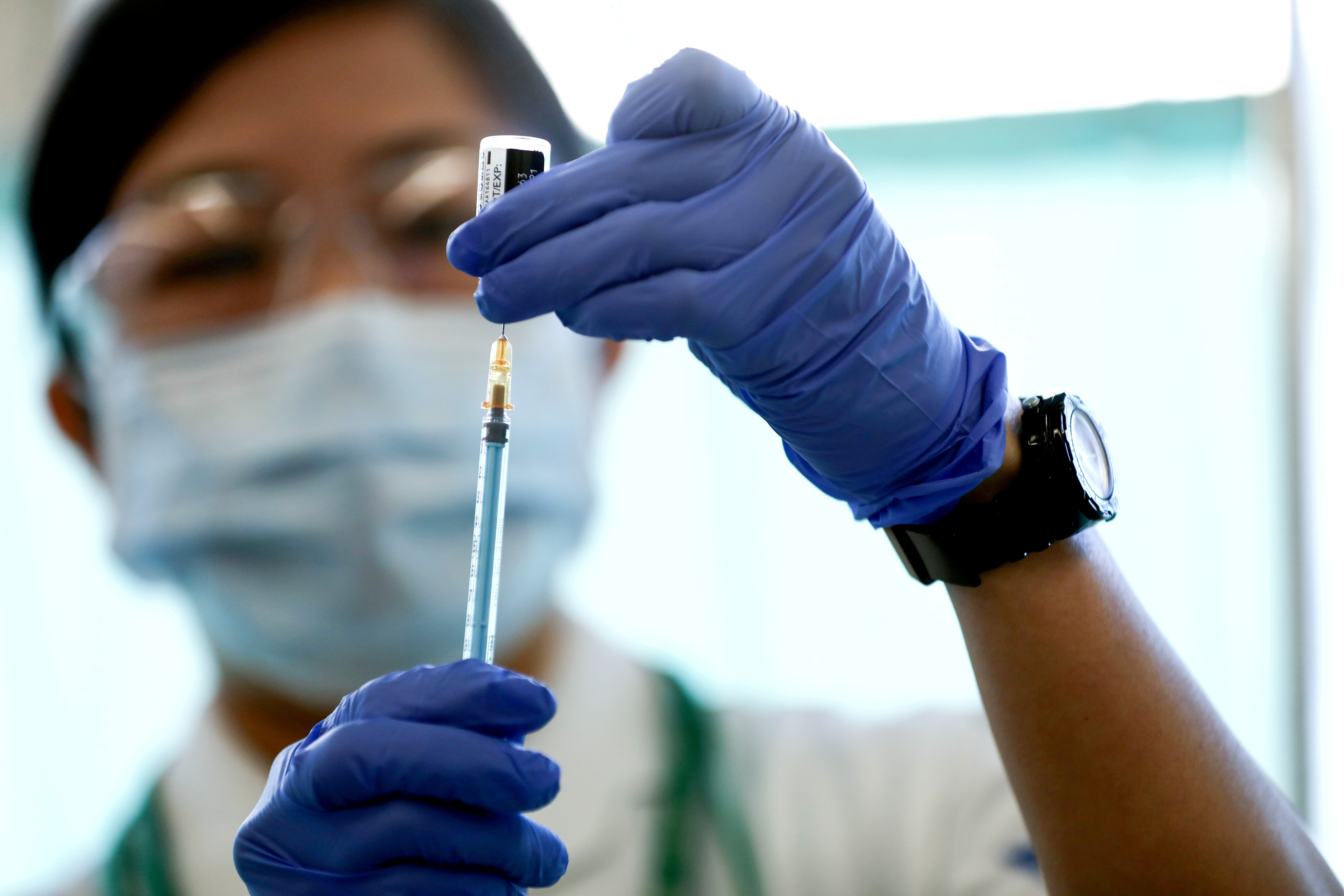A medical worker fills a syringe with a dose of the Pfizer-BioNTech coronavirus disease (COVID-19) vaccine as Japan launches its inoculation campaign, at Tokyo Medical Center in Tokyo