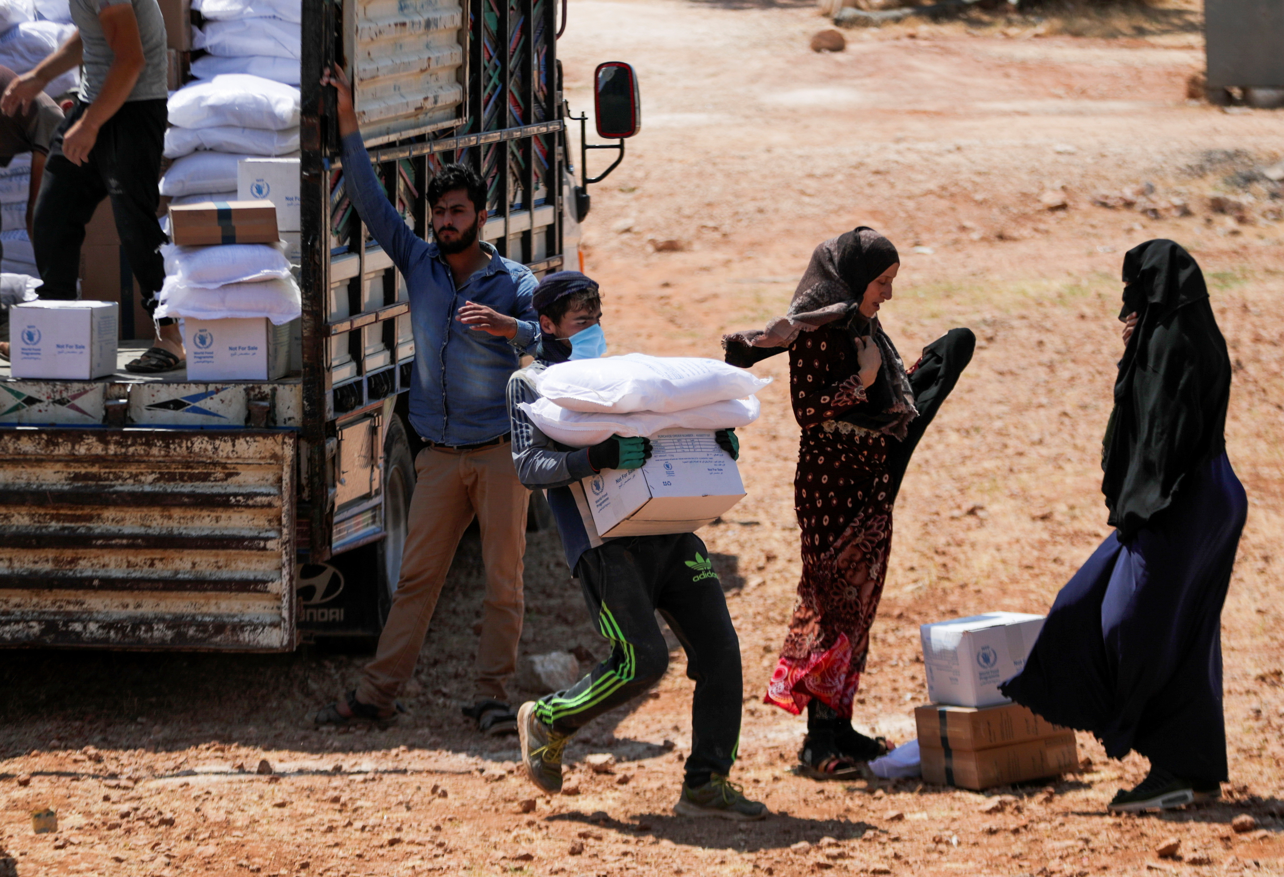 A worker holds bags and a box of humanitarian aid in the opposition-held Idlib