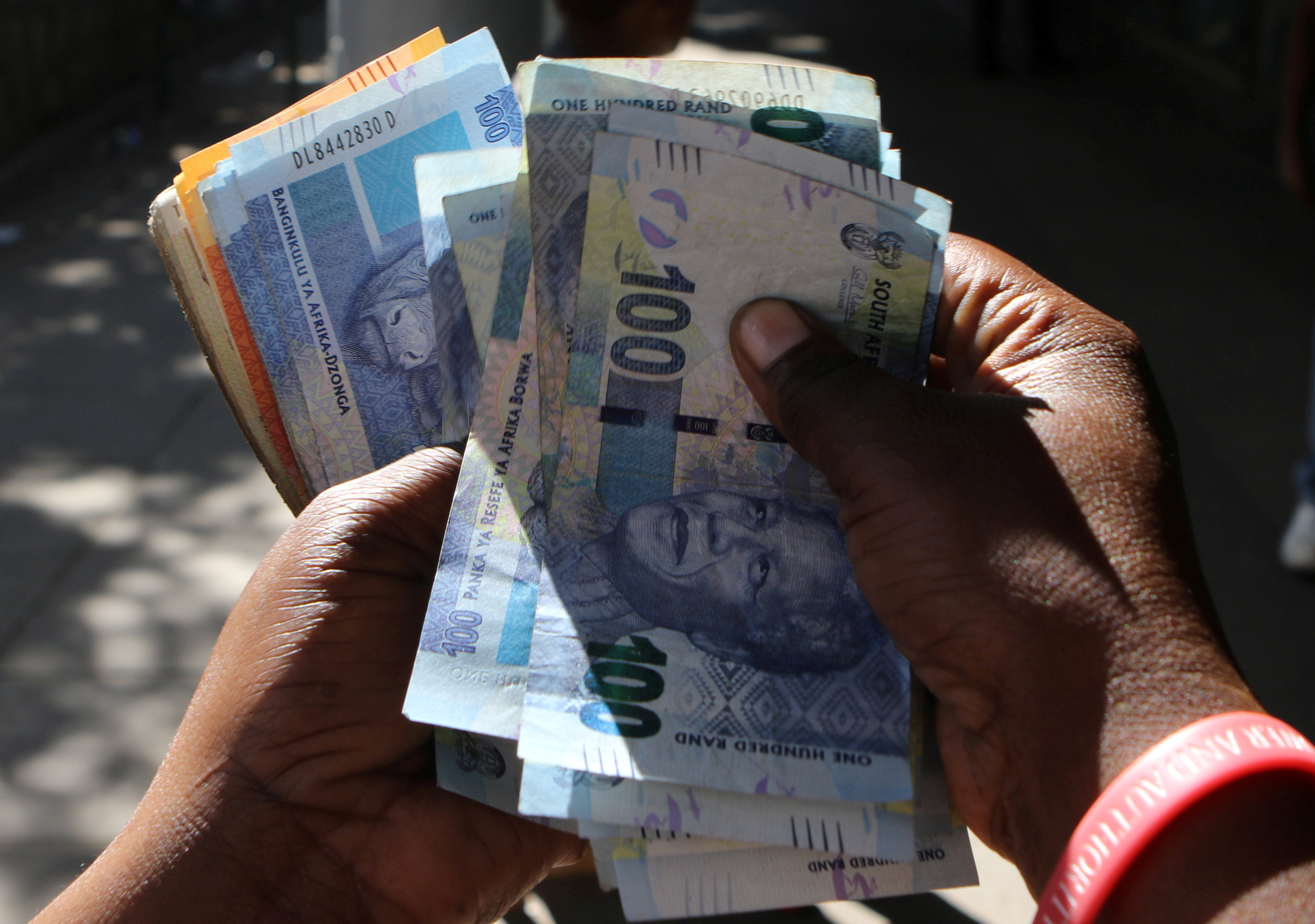 A street money changer counts South African Rands in Harare