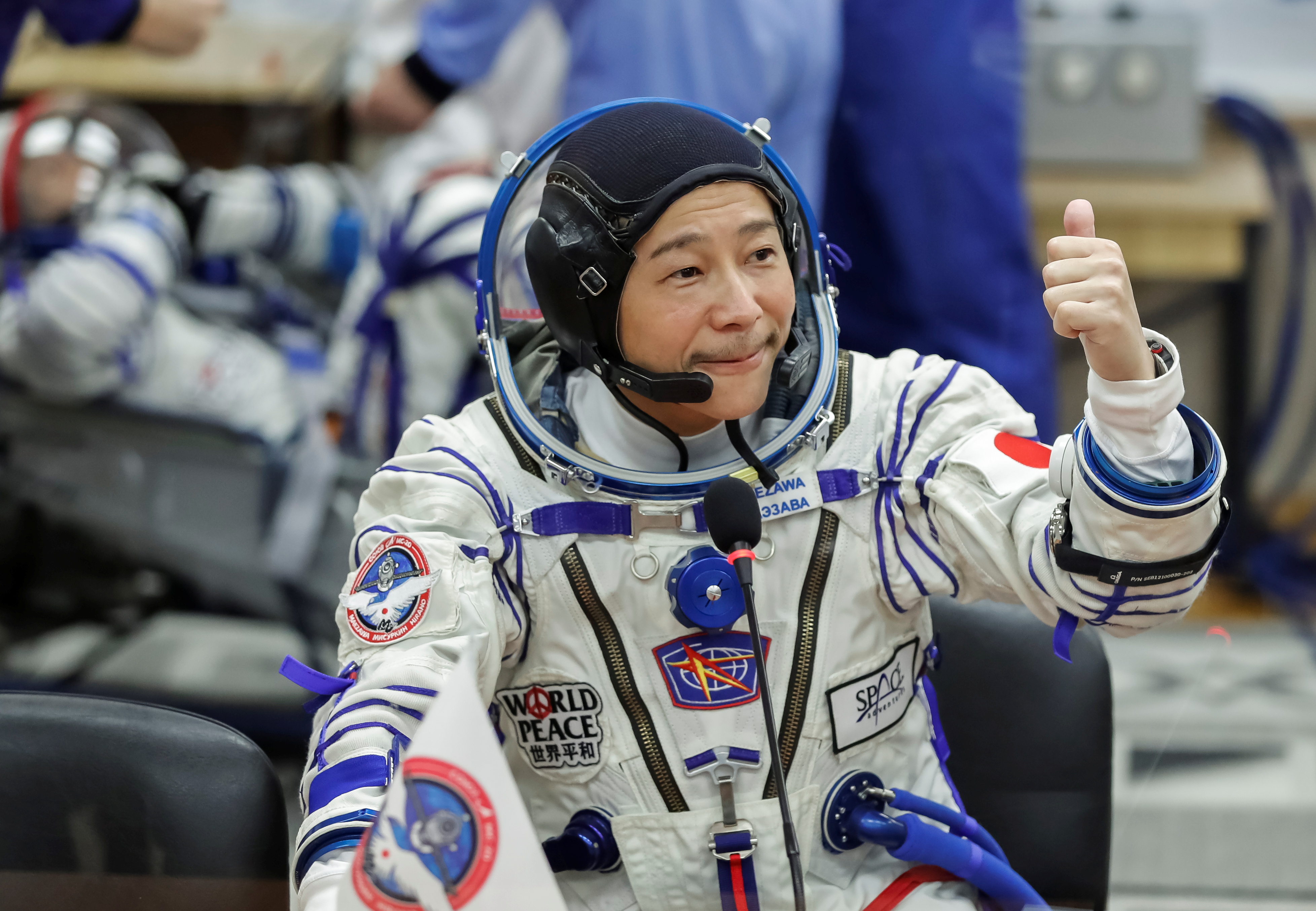 Japanese entrepreneur Yusaku Maezawa reacts as he talks to his family after donning his space suits shortly before launching to the International Space Station (ISS) at the Baikonur Cosmodrome