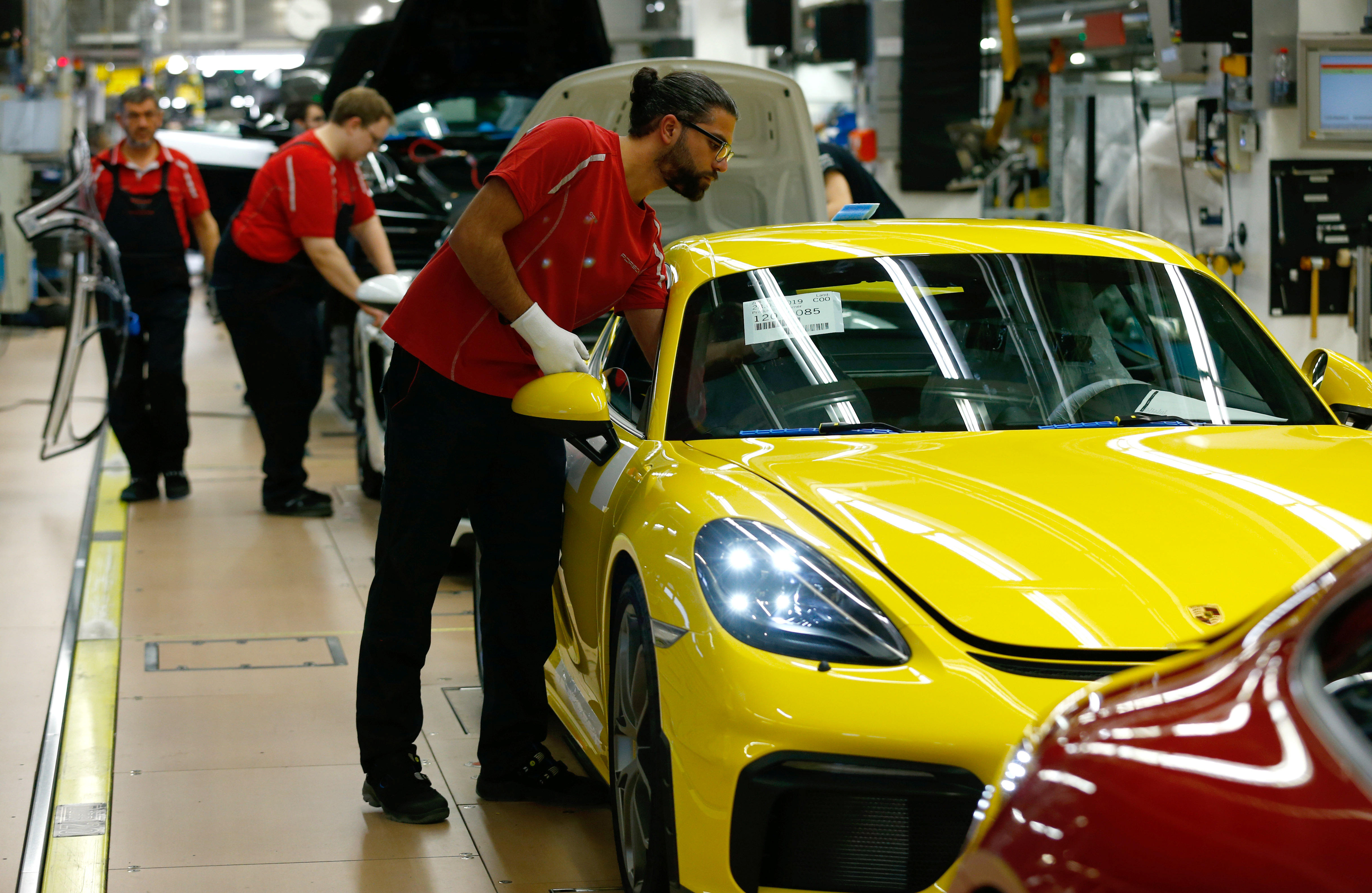 Employees of German car manufacturer Porsche assemble sports cars at the Porsche factory in Stuttgart-Zuffenhausen