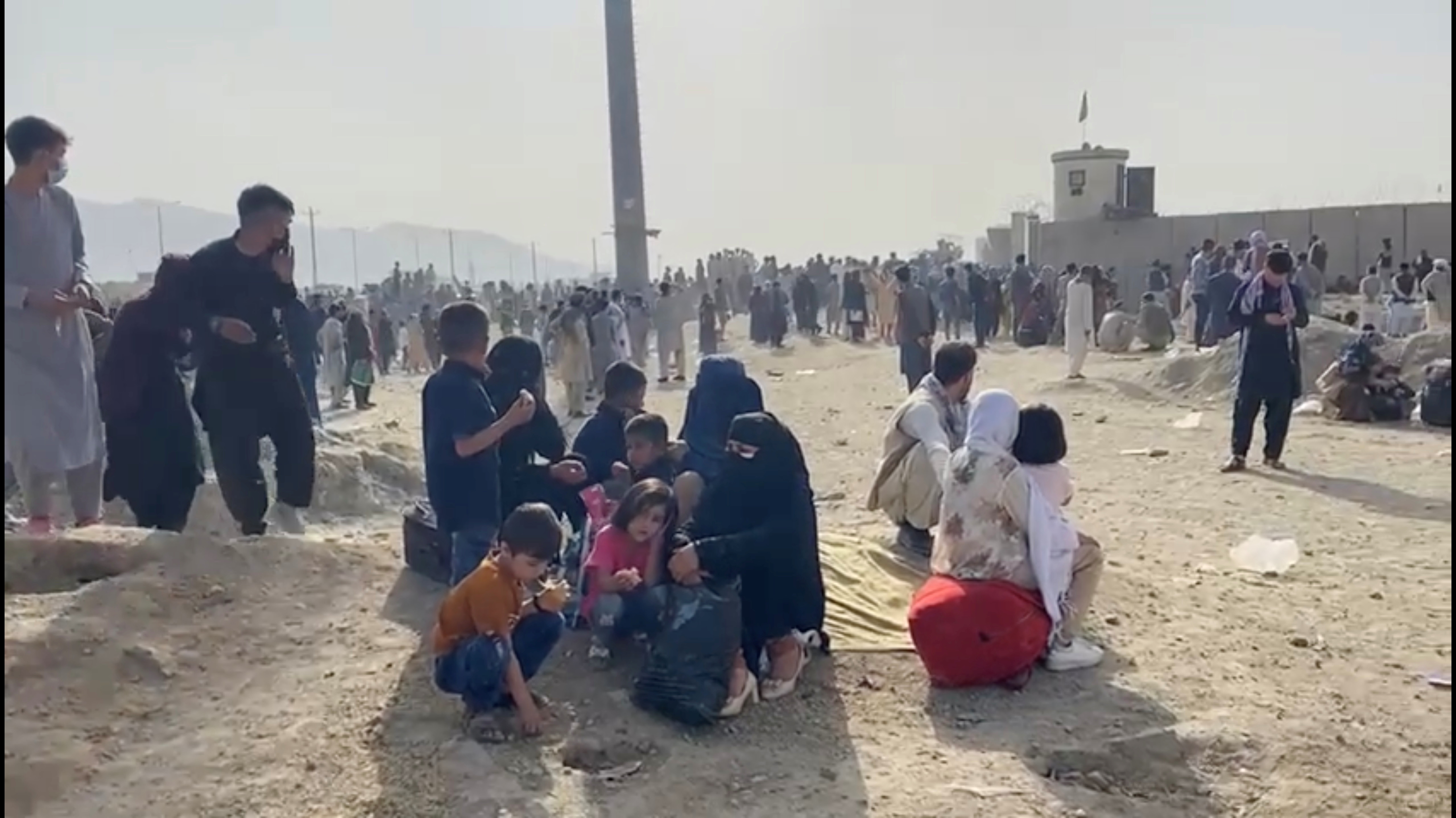 People gathered outside the airport react to gunfire, in Kabul, Afghanistan August 18, 2021 in this still image taken from video. ASVAKA NEWS via REUTERS   