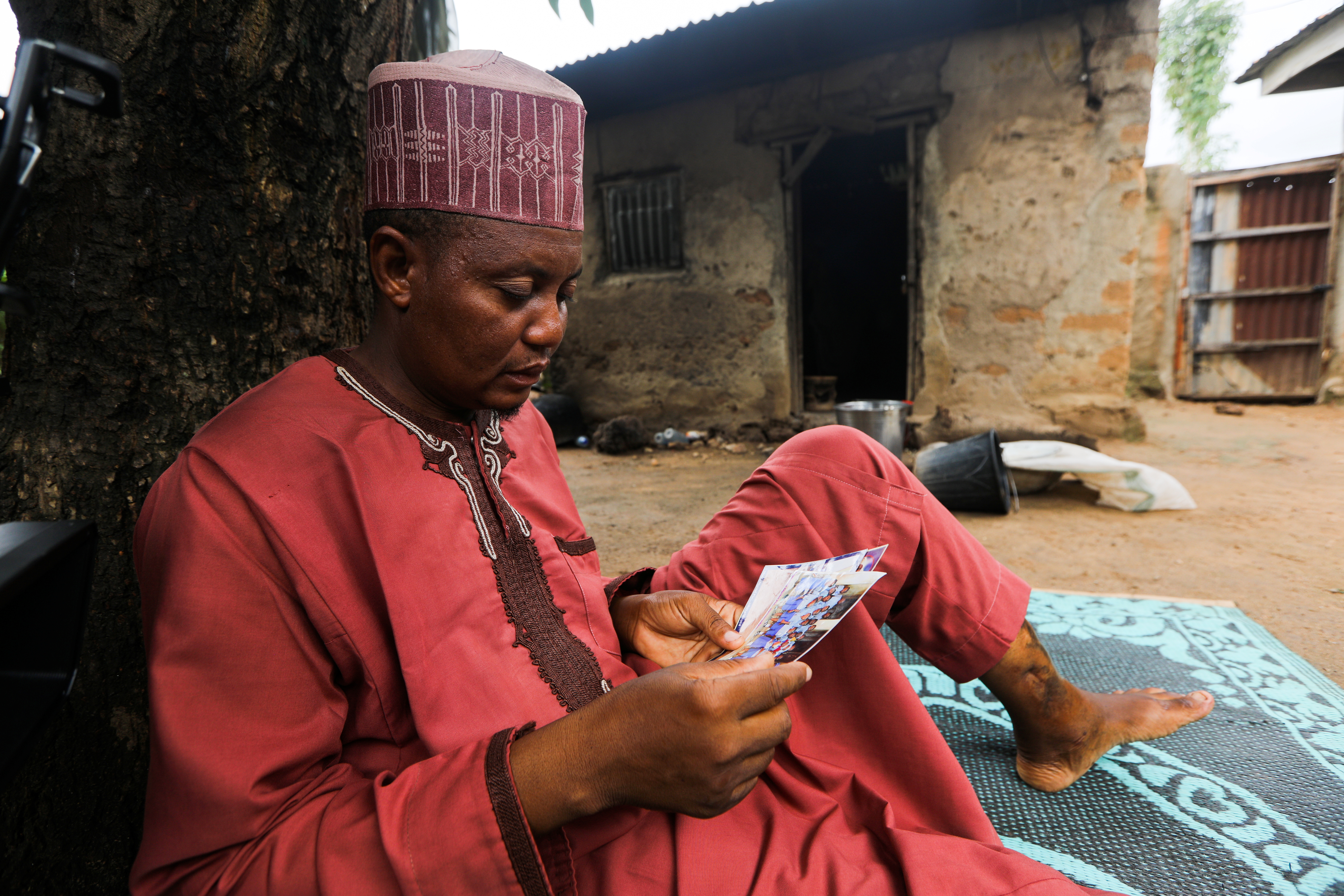 Aminu Salisu, a parent, looks at the pictures of one of the children kidnapped by bandits at Salihu Tanko Islamic school in Tegina, Niger State