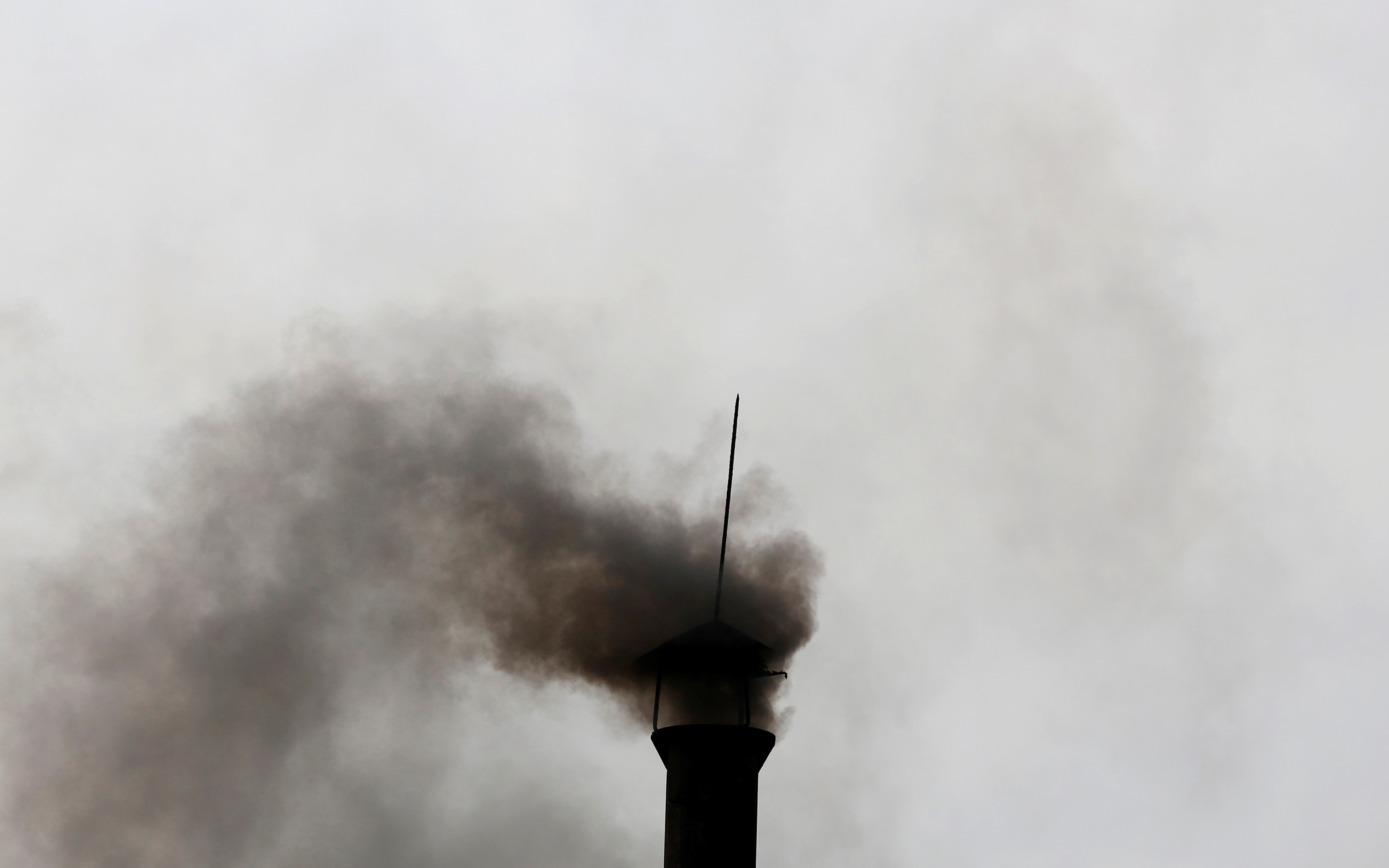 Smoke rises from the chimney of a paper factory outside Hanoi