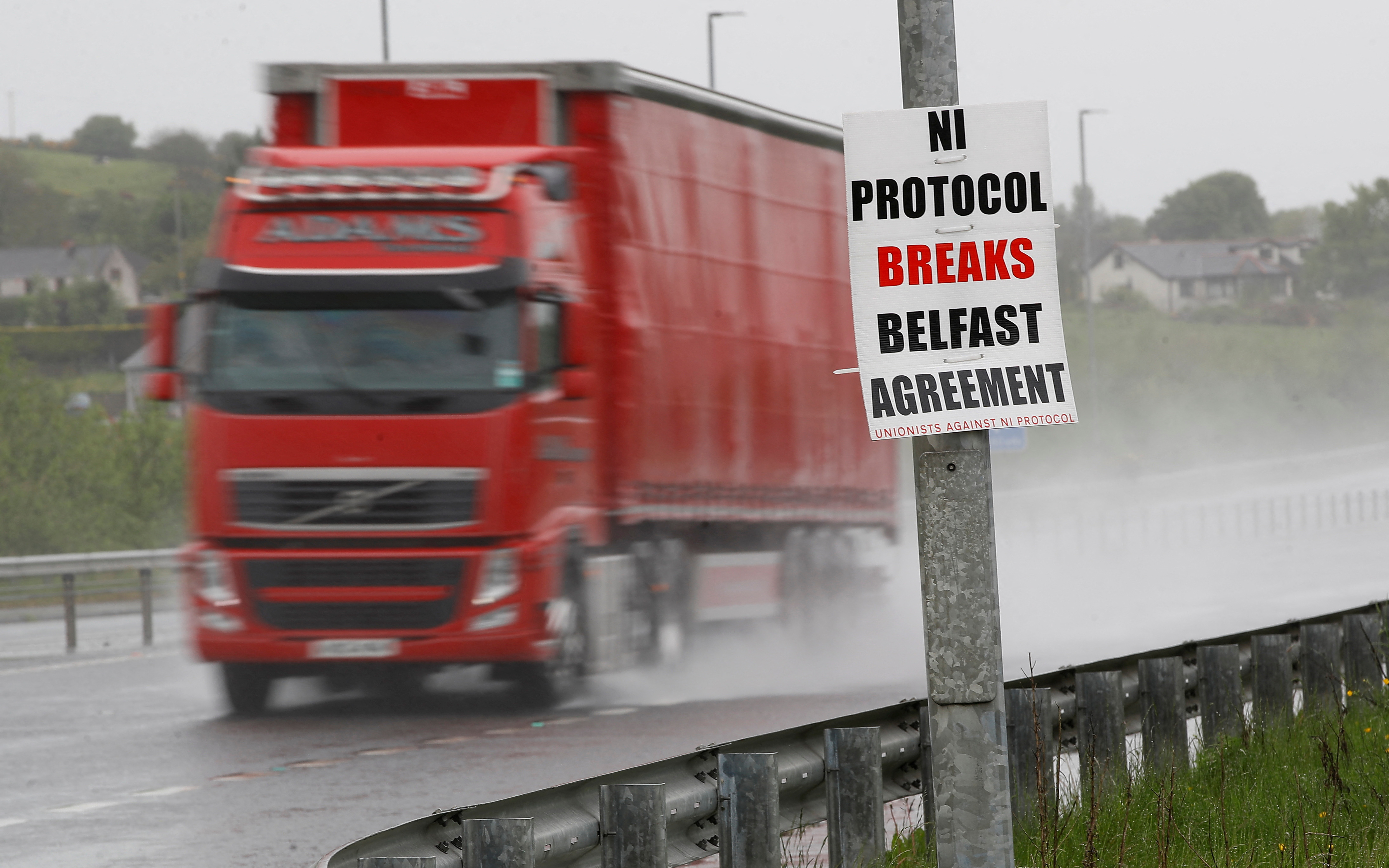 An anti-northern Ireland protocol poster is seen next to a road approaching Larne