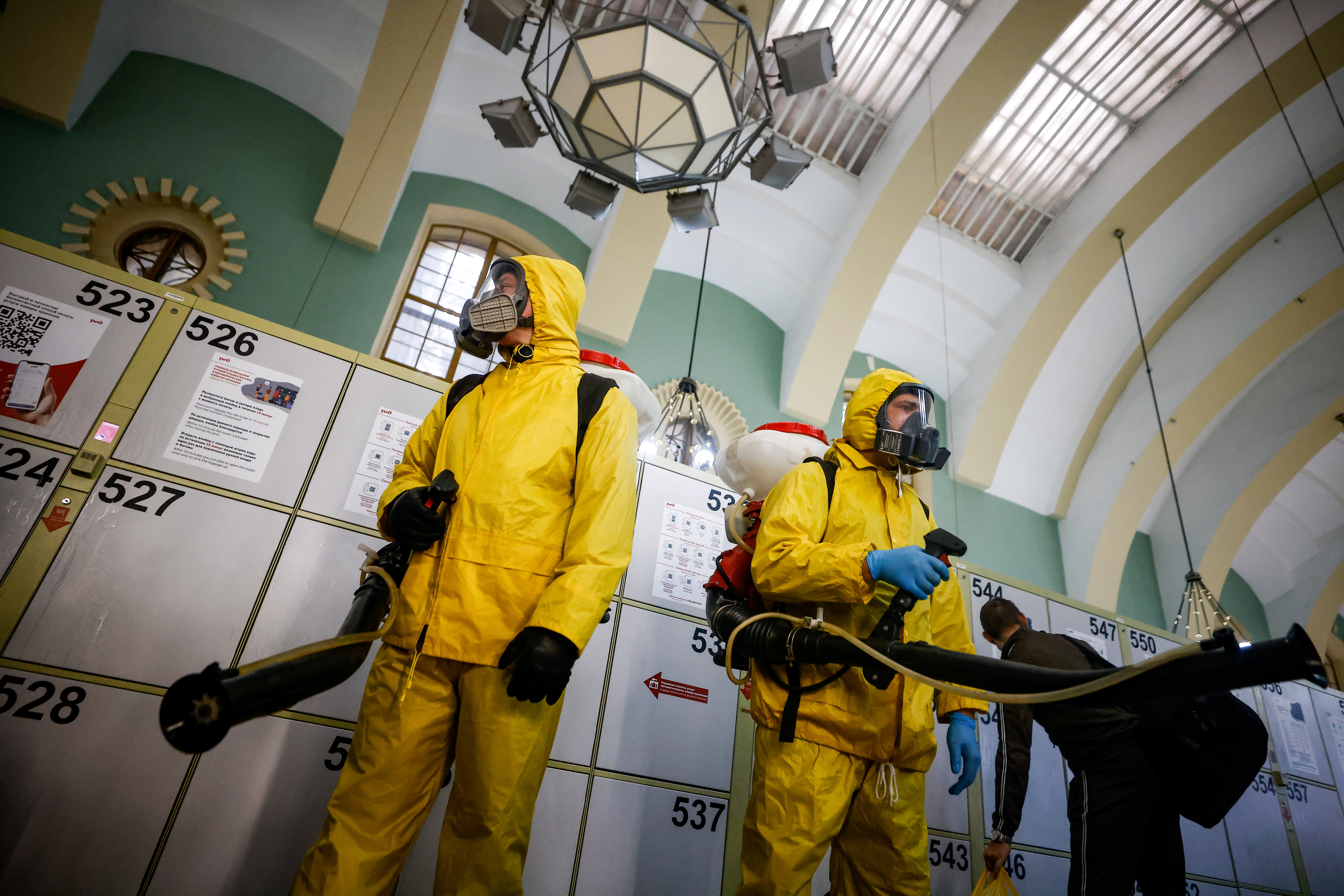 Para ahli mengenakan alat pelindung diri (APD) menyemprotkan disinfektan saat membersihkan stasiun kereta api Kazansky di tengah merebaknya penyakit virus corona (COVID-19) di Moskow, Rusia, 2 November 2021. REUTERS/Maxim Shemetov