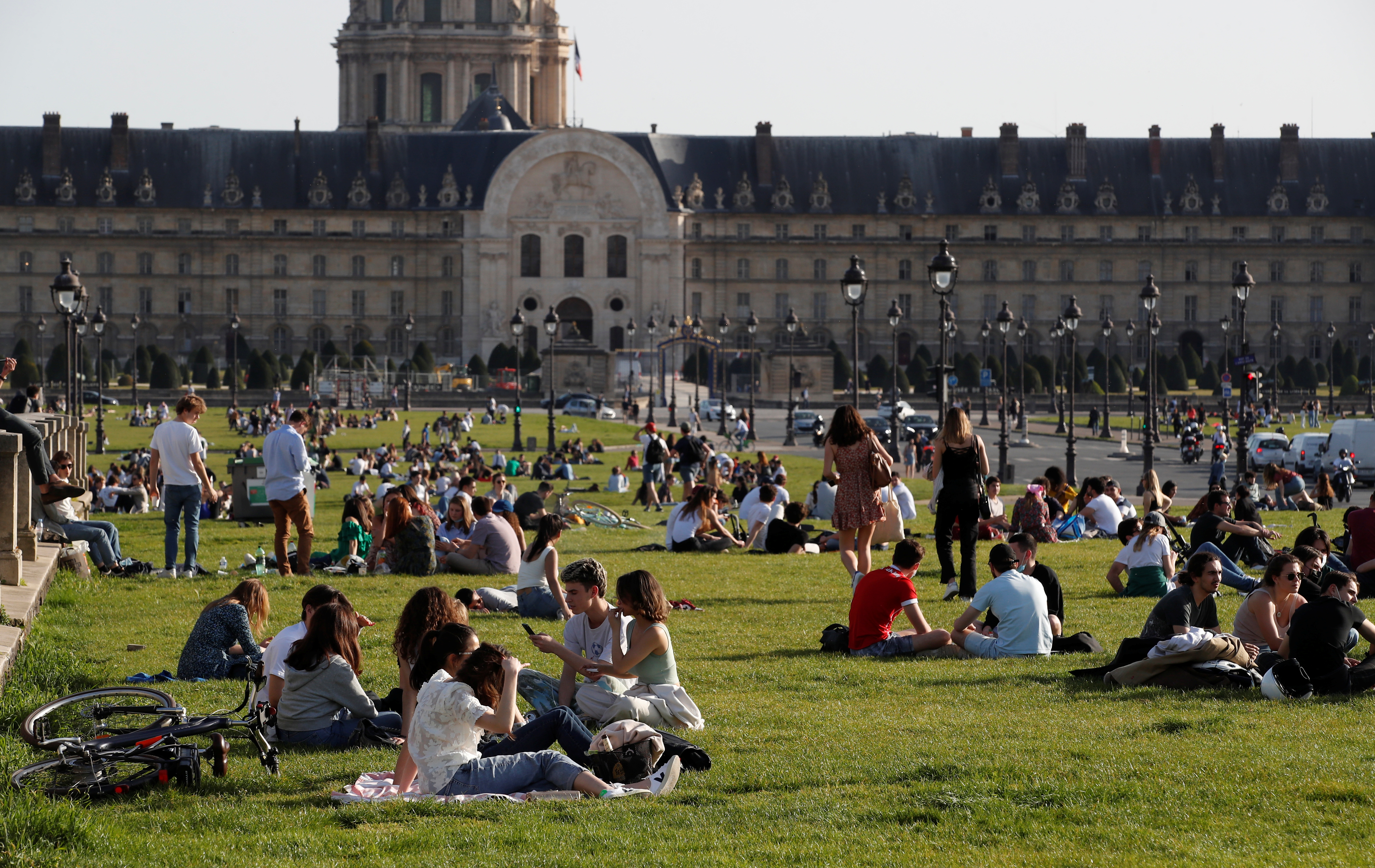 People enjoy a sunny and warm weather sitting on the grass near the Invalides in Paris amid the coronavirus disease (COVID-19) outbreak in France, March 31, 2021.  REUTERS/Gonzalo Fuentes