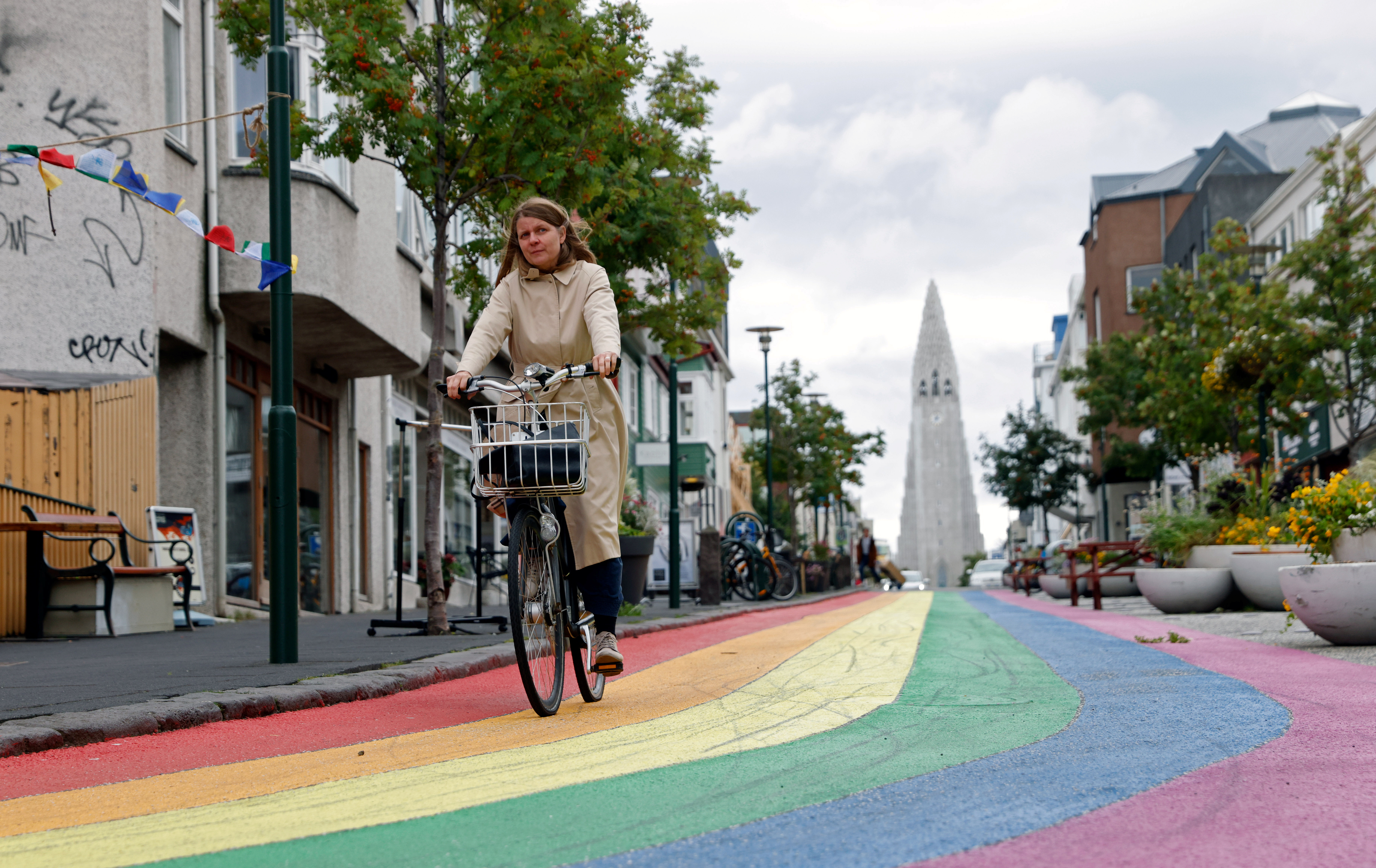A woman cycles down a street painted in rainbow colours near the Hallgrimskirkja church, as the outbreak of the coronavirus disease (COVID-19) continues, in Reykjavik