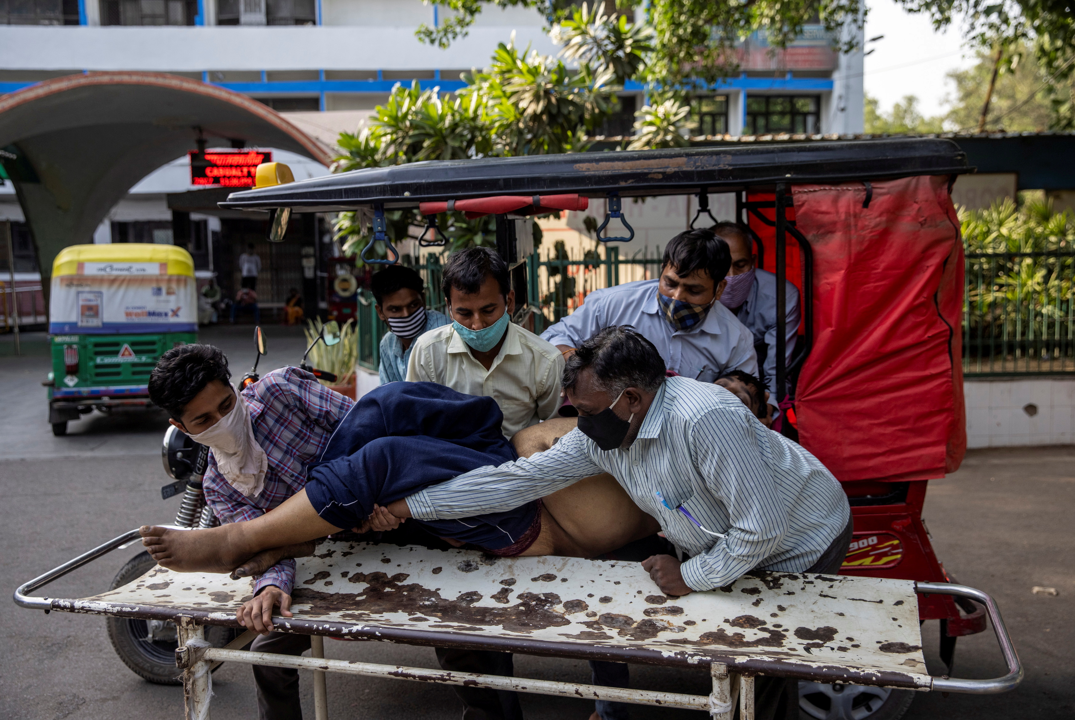 Shayam Narayan is brought to the coronavirus disease (COVID-19) casualty ward by his family members in a rickshaw, at Guru Teg Bahadur hospital, amidst the spread of the disease in New Delhi, India, April 23, 2021. REUTERS/Danish Siddiqui  