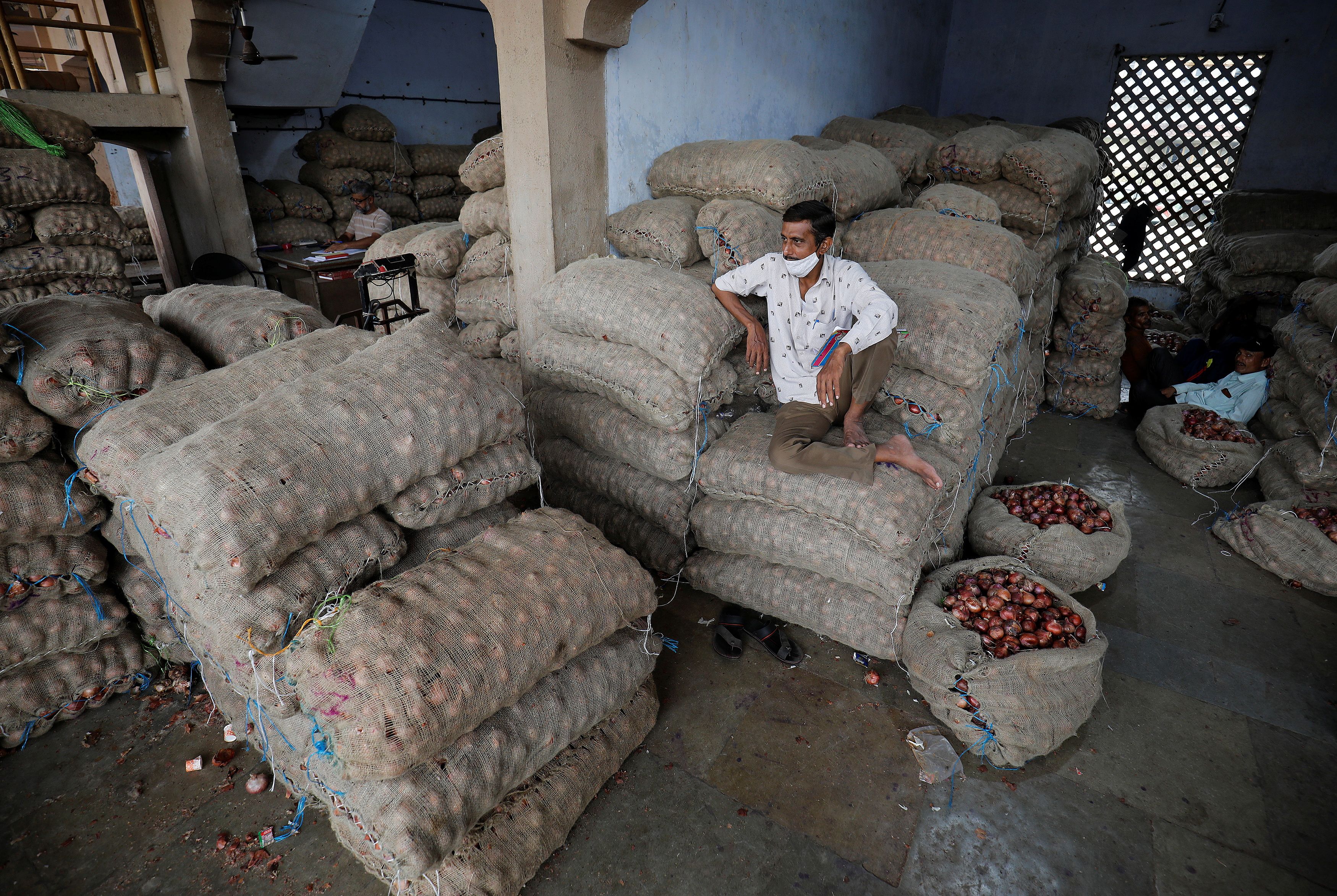 A vendor waits for customers at a vegetable market in Ahmedabad