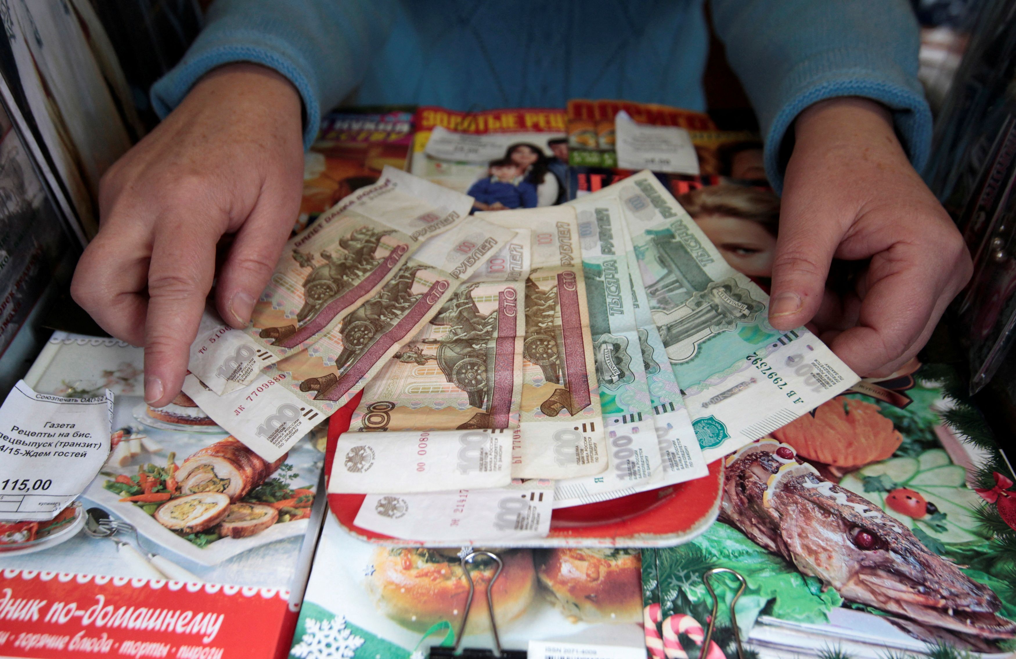 Vendor demonstrates rouble banknotes in Stavropol