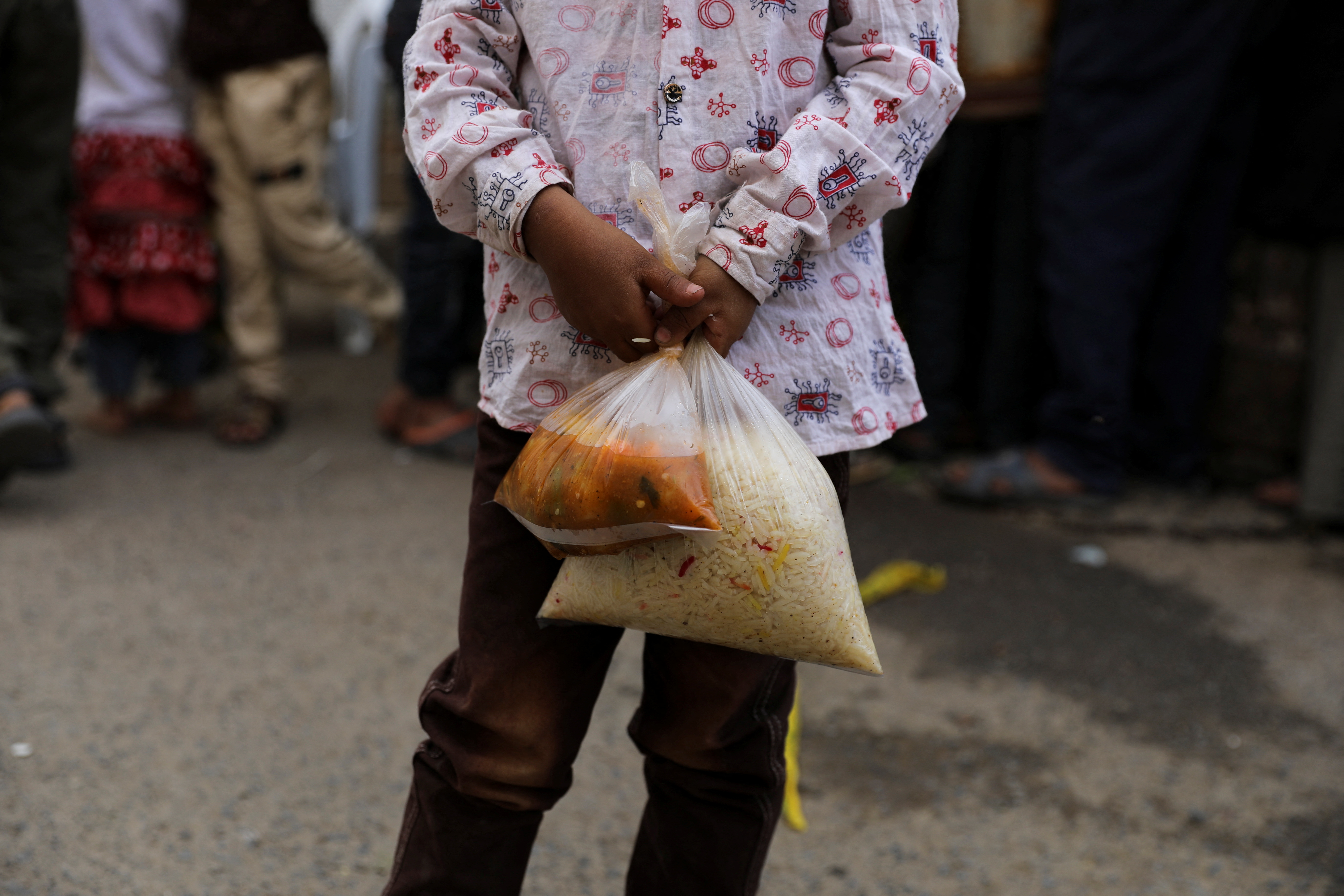 Boy holds a meal received from a charity kitchen during the holy month of Ramadan in Sanaa