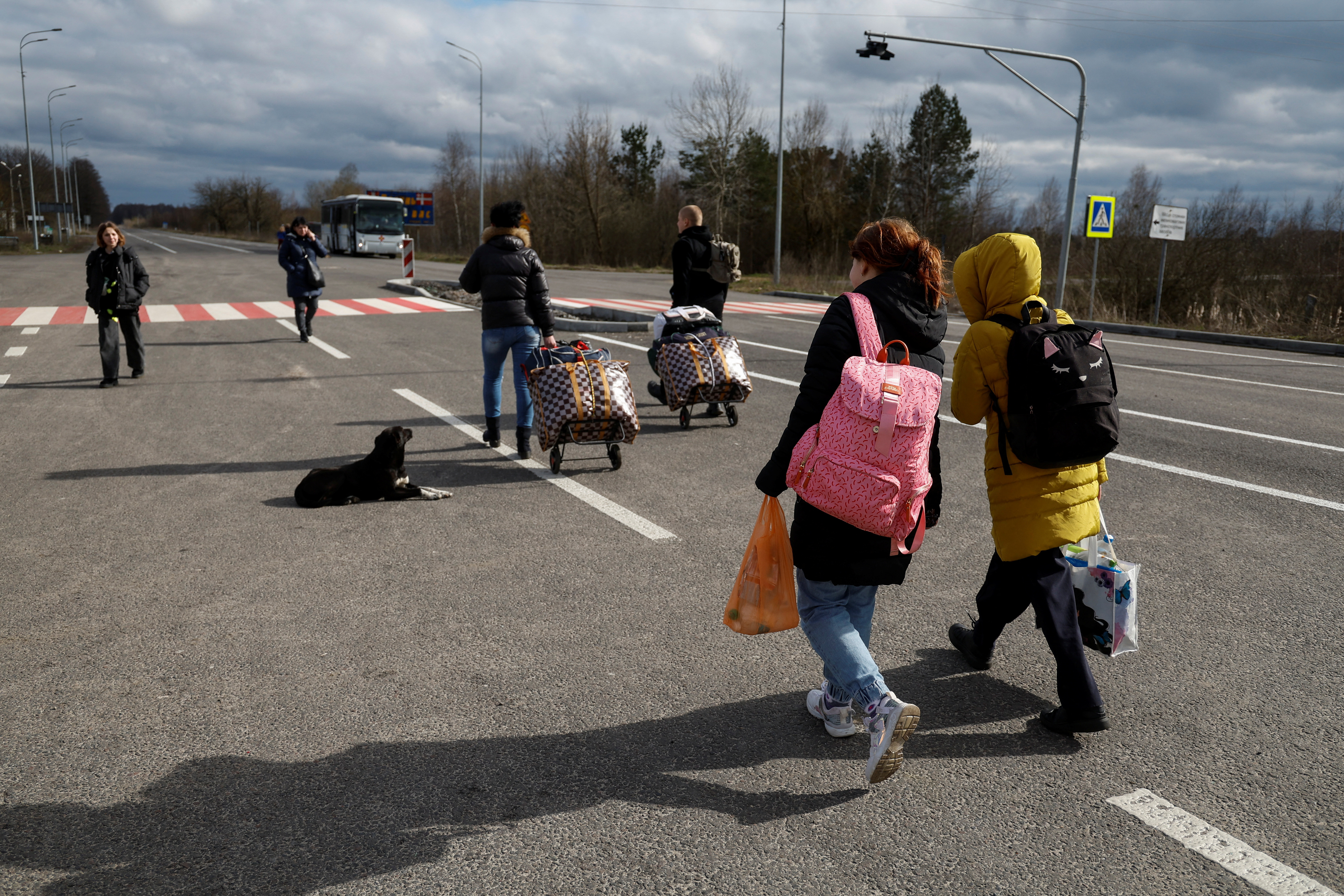 Children taken to Russia walk to a bus after returning via the Ukraine-Belarus border, in Volyn region