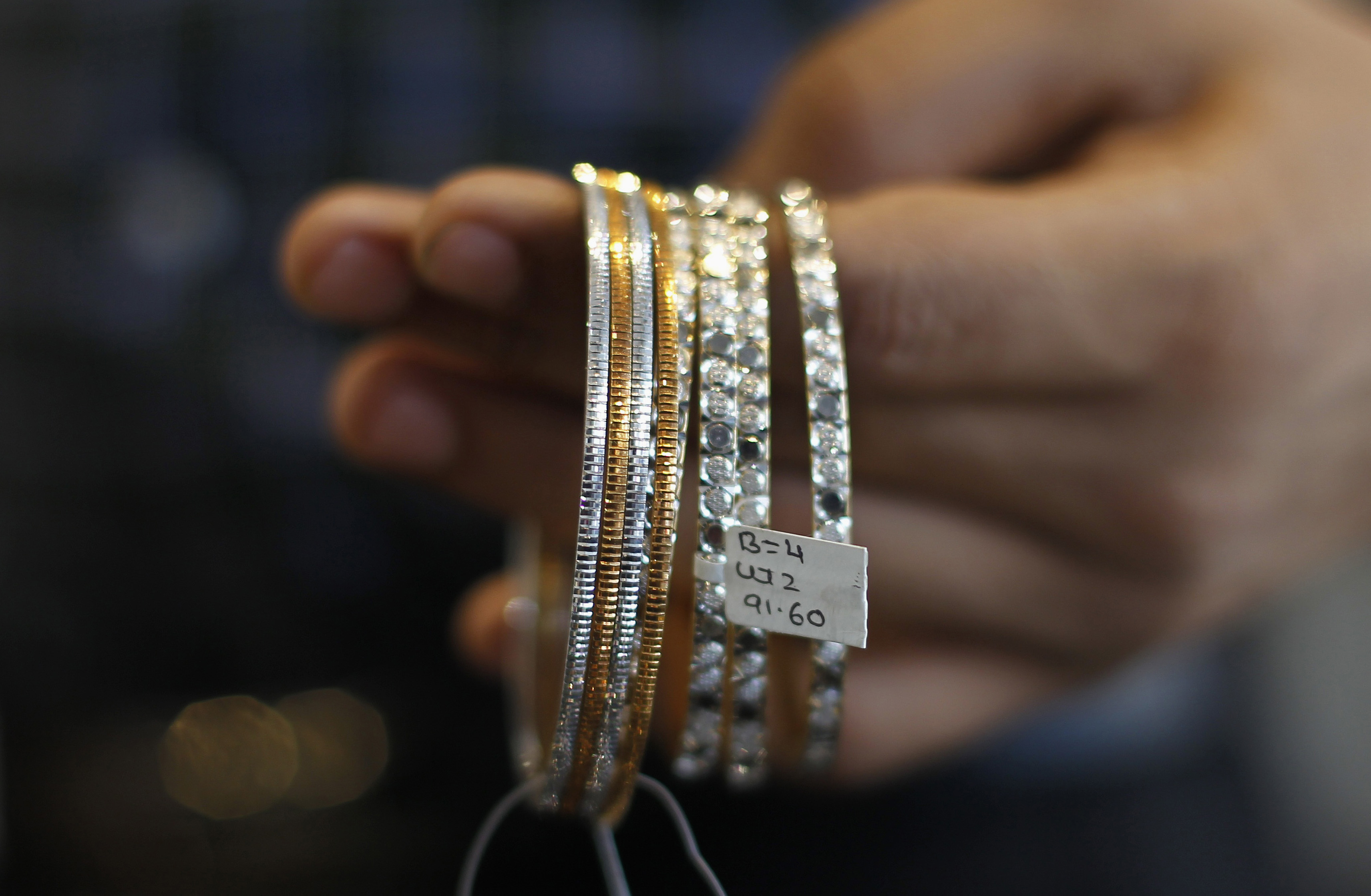 A salesman displays platinum bangles for the camera at a jewellery showroom in Mumbai