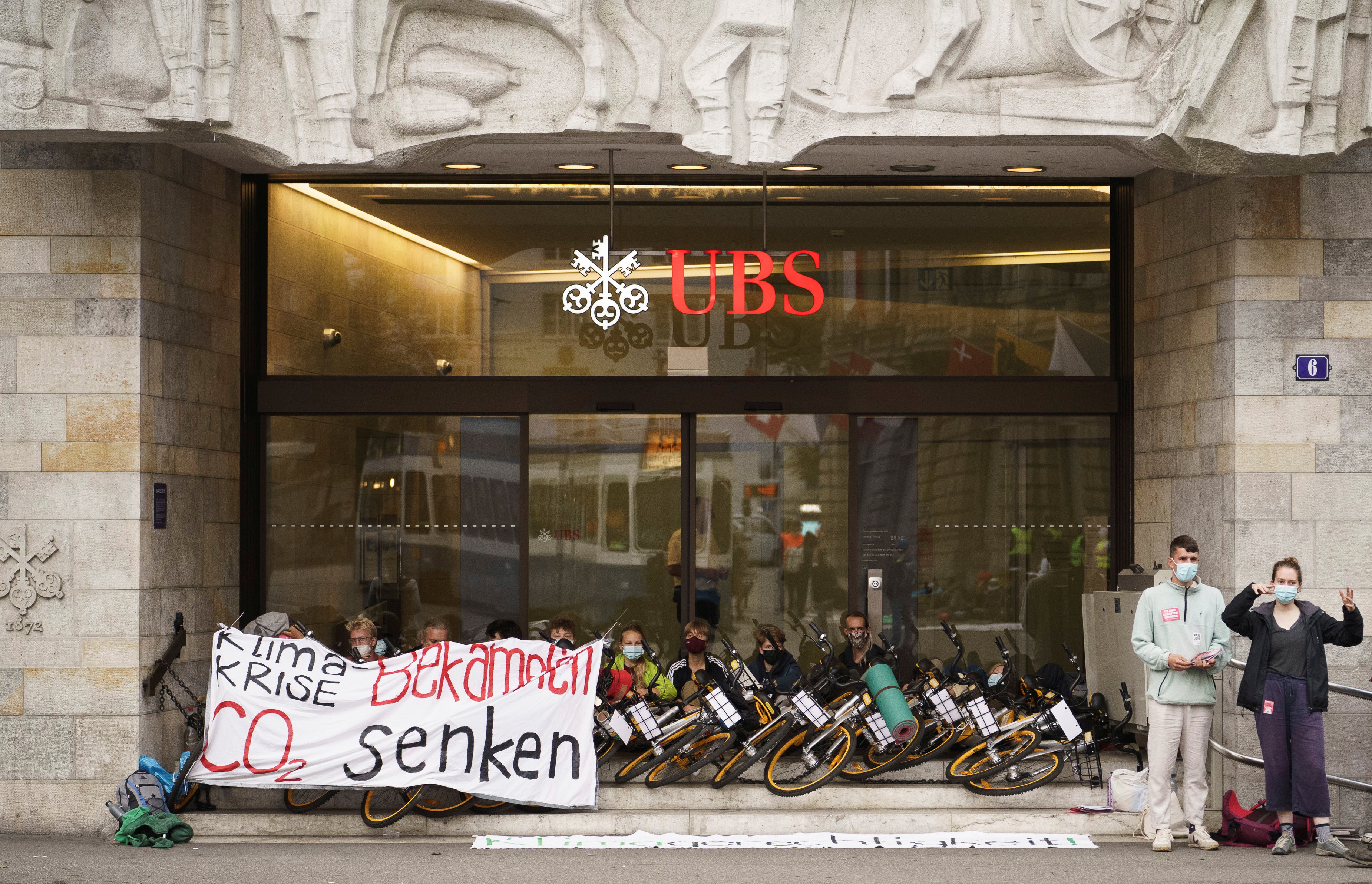 Climate activists of "Rise up for Change" block an entrance of UBS to protest against big banks' financing of fossil fuel projects that damage the environment in Zurich, Germany, August 2, 2021. Schweiz Rise Up For Change/Handout via REUTERS 