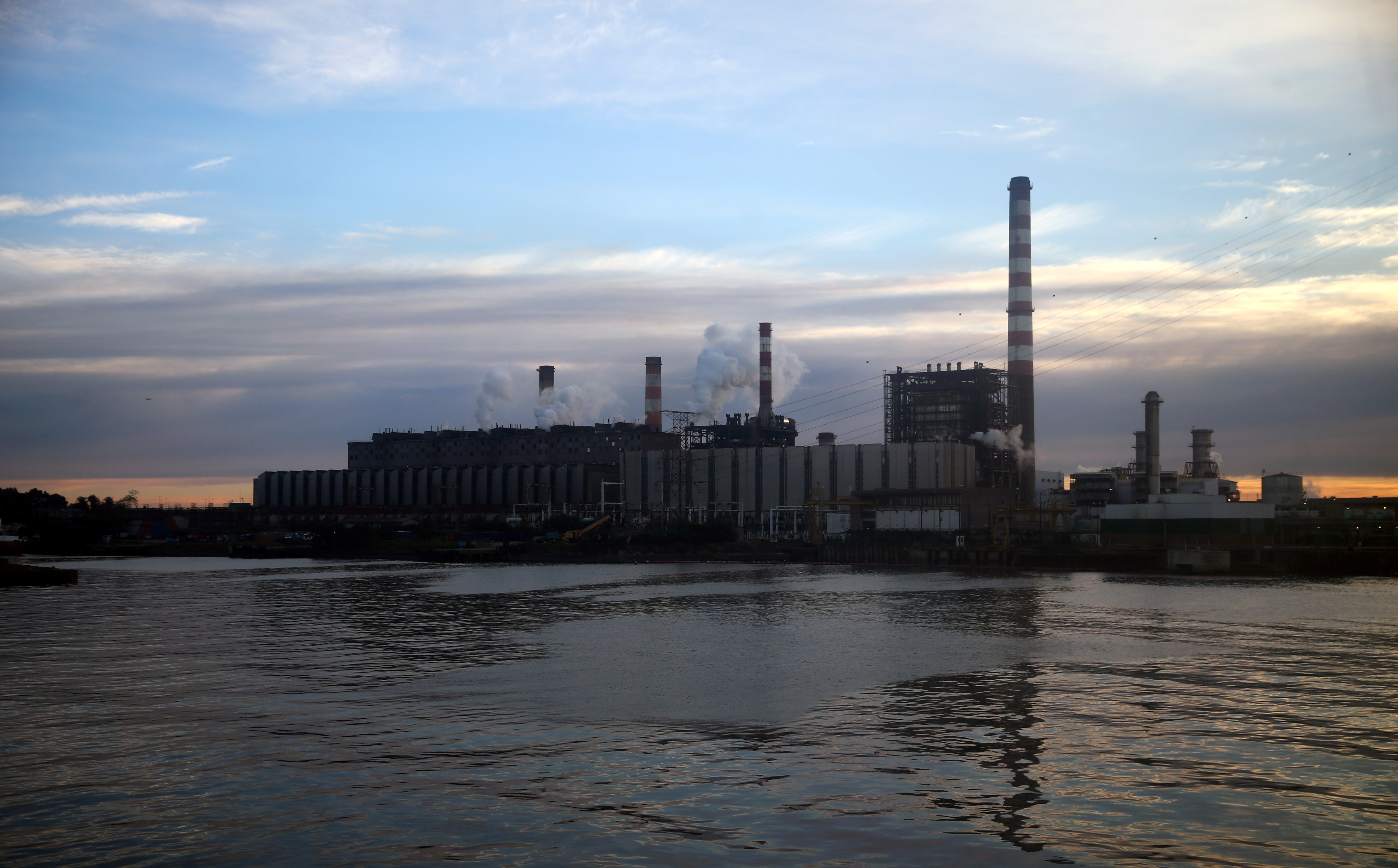 Smoke comes out of an electric plant on the shore of the polluted River Plate in Buenos Aires