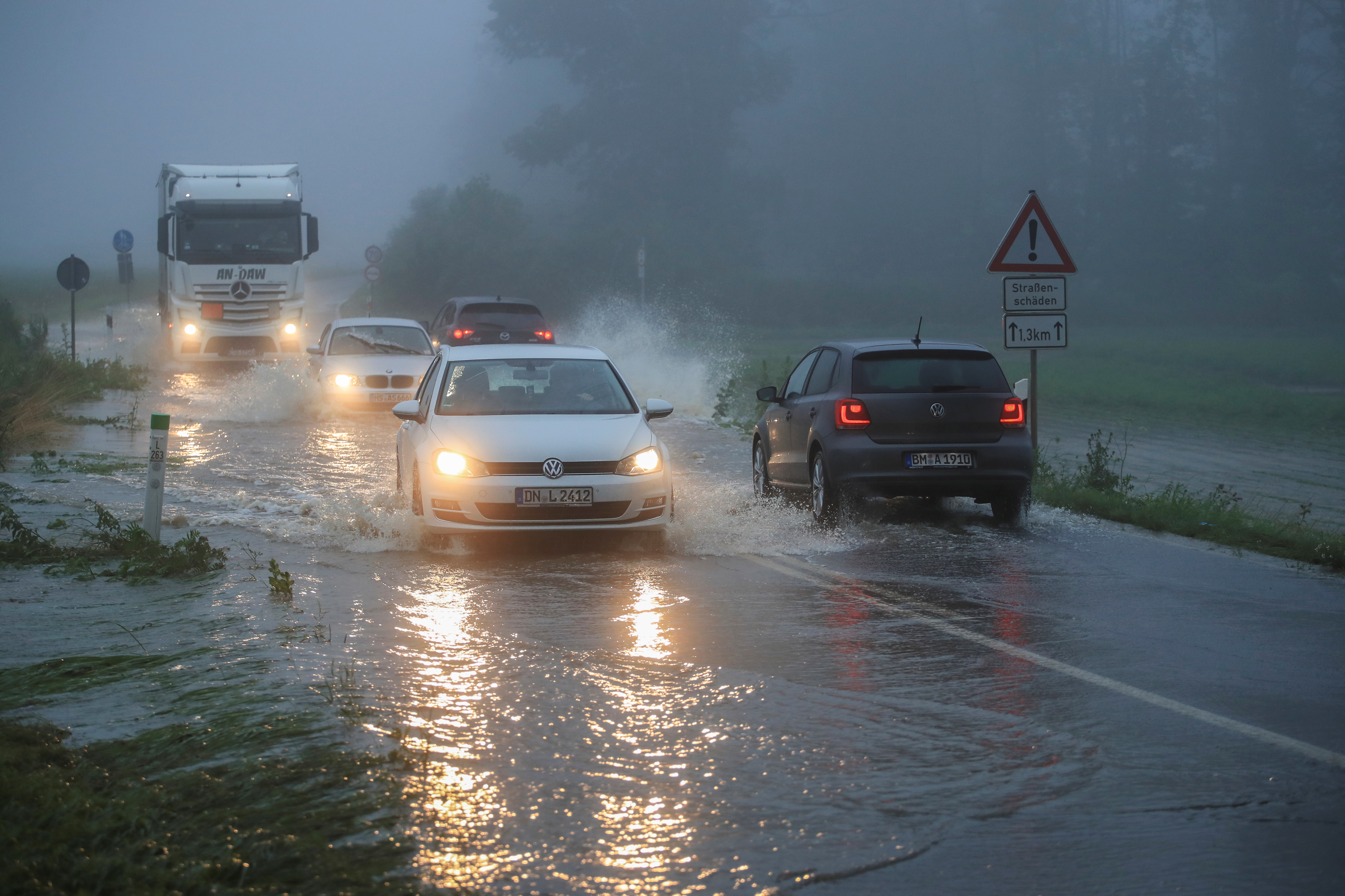 Vehicles travel on a flood affected road after the Erft river swelled following heavy rainfalls in Erftstadt, near Cologne, Germany, July 15, 2021. REUTERS/Wolfgang Rattay