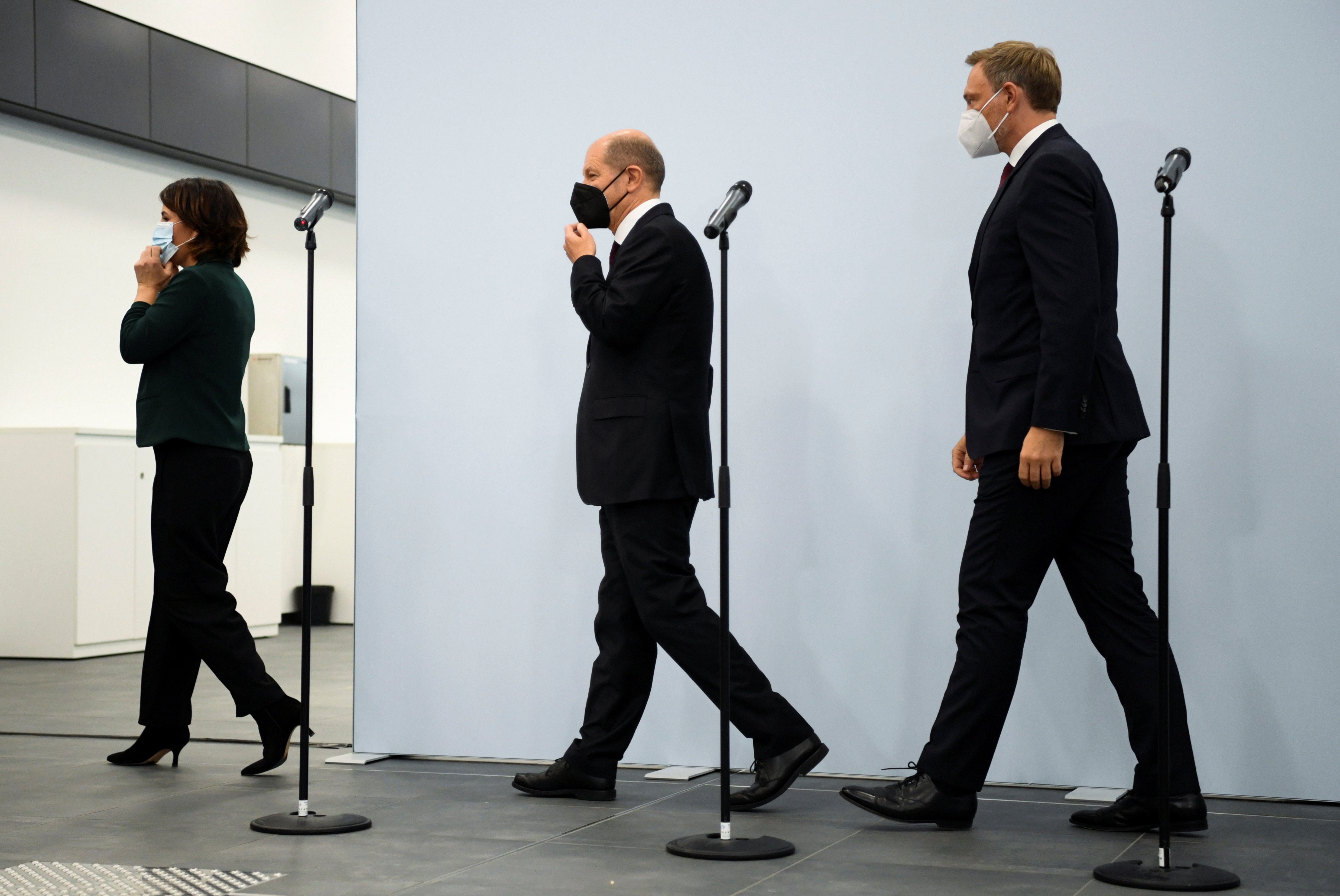 Germany's Greens party co-leader Annalena Baerbock, Social Democratic Party (SPD) top candidate for chancellor Olaf Scholz and Free Democratic Party (FDP) leader Christian Lindner leave after a statement following a meeting for exploratory talks for a possible new government coalition in Berlin, Germany, October 15, 2021. REUTERS/Annegret Hilse