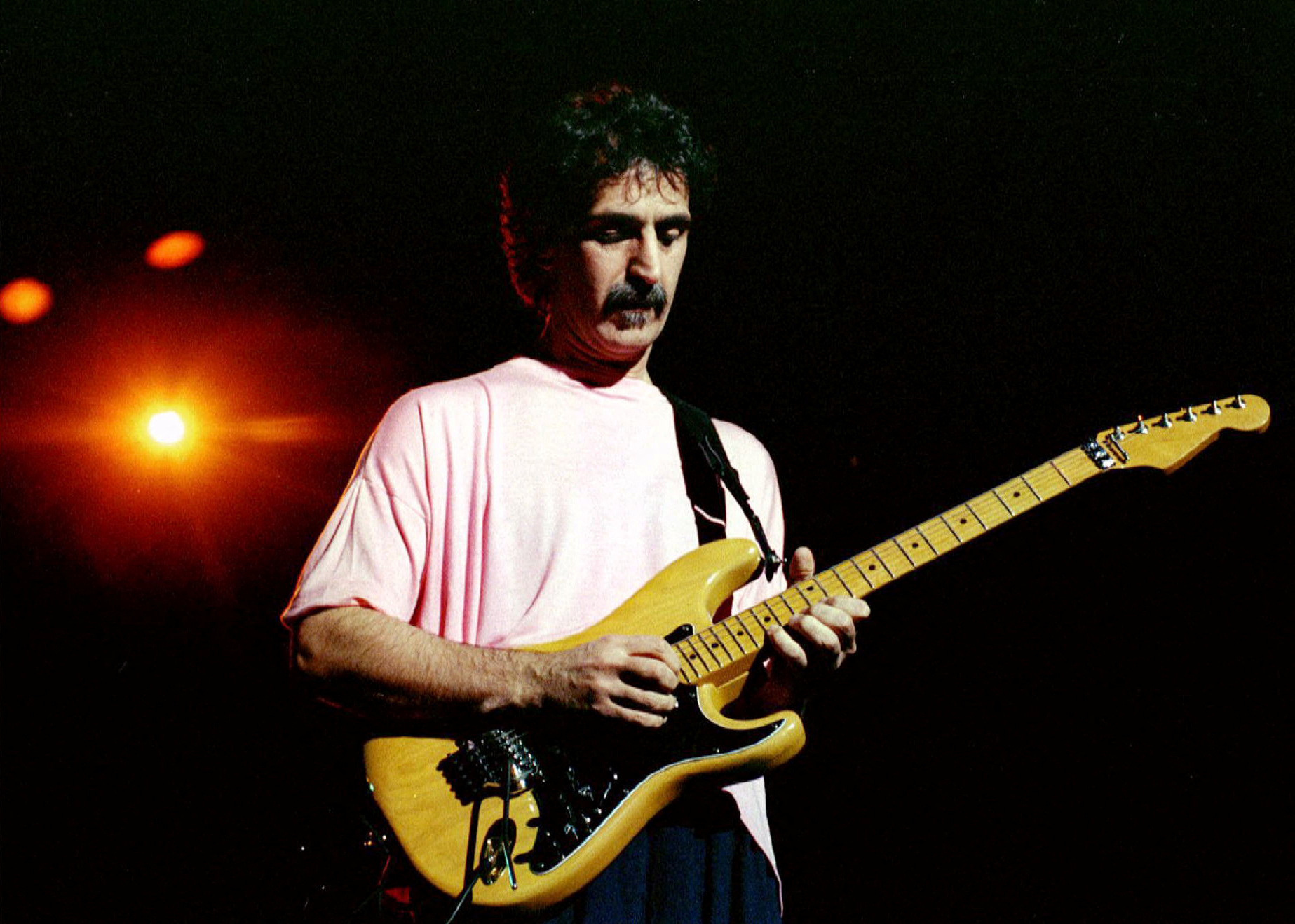 Rock musician Frank Zappa plays guitar during a concert at the Warner Theatre in Washington