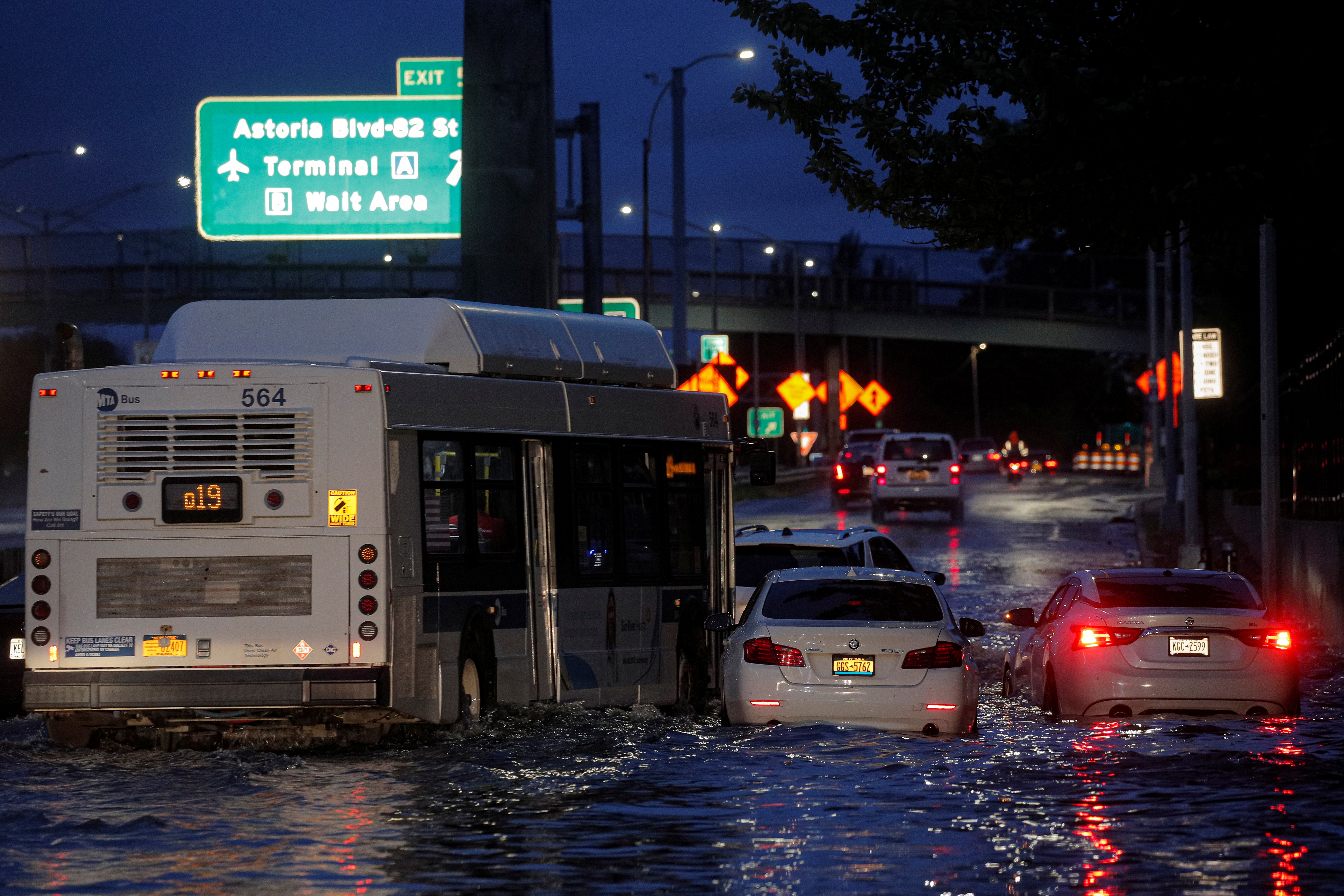 A bus navigates past abandoned cars on a flooded highway, as local media reported the remnants of Tropical Storm Ida bringing drenching rain and the threat of flash floods and tornadoes to parts of the northern mid-Atlantic, in the Queens borough of New York City, U.S., September 2, 2021.  REUTERS/Brendan McDermid