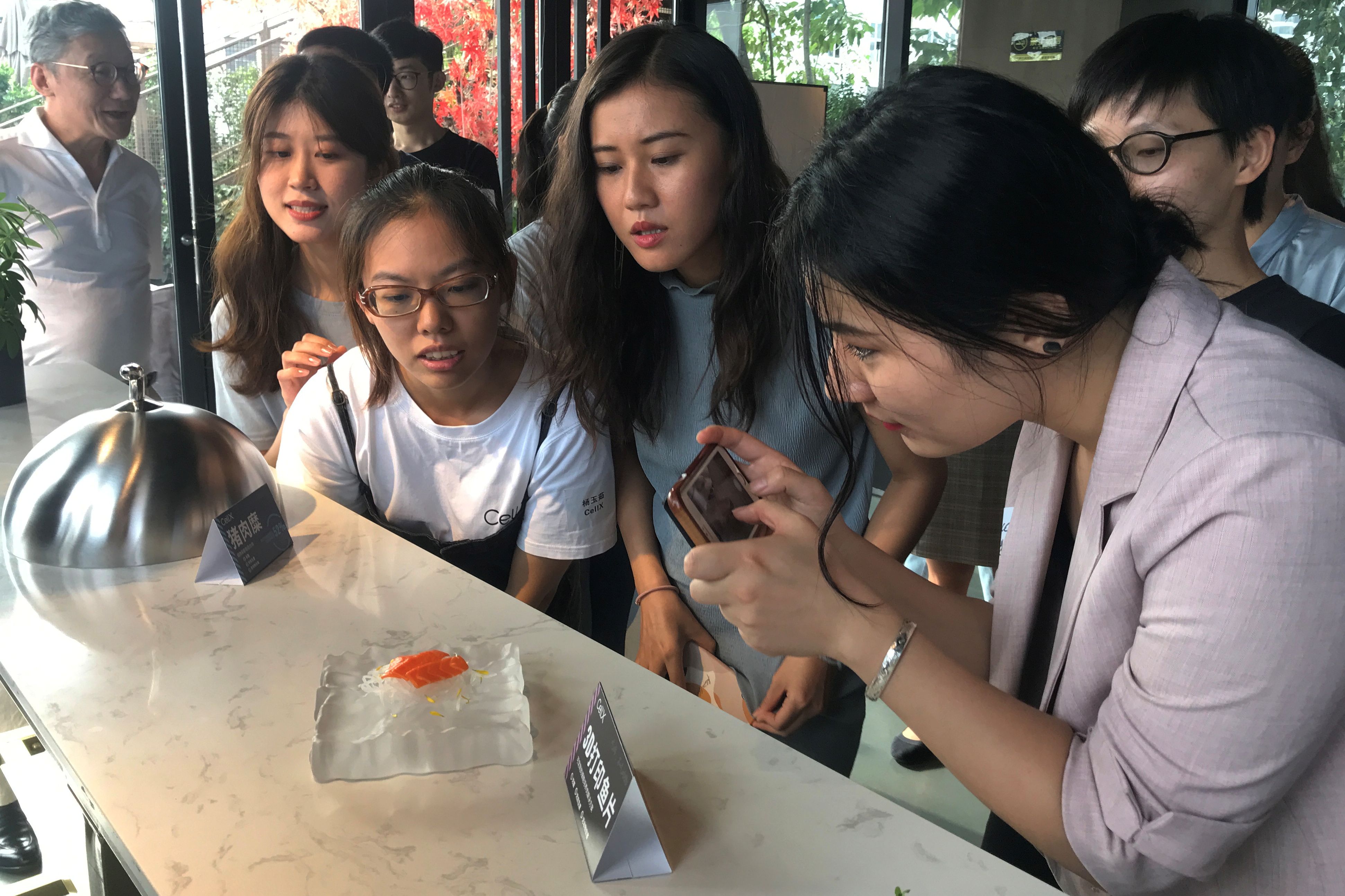 Guests look at a 3D printed salmon slice displayed during an event by CellX in Shanghai