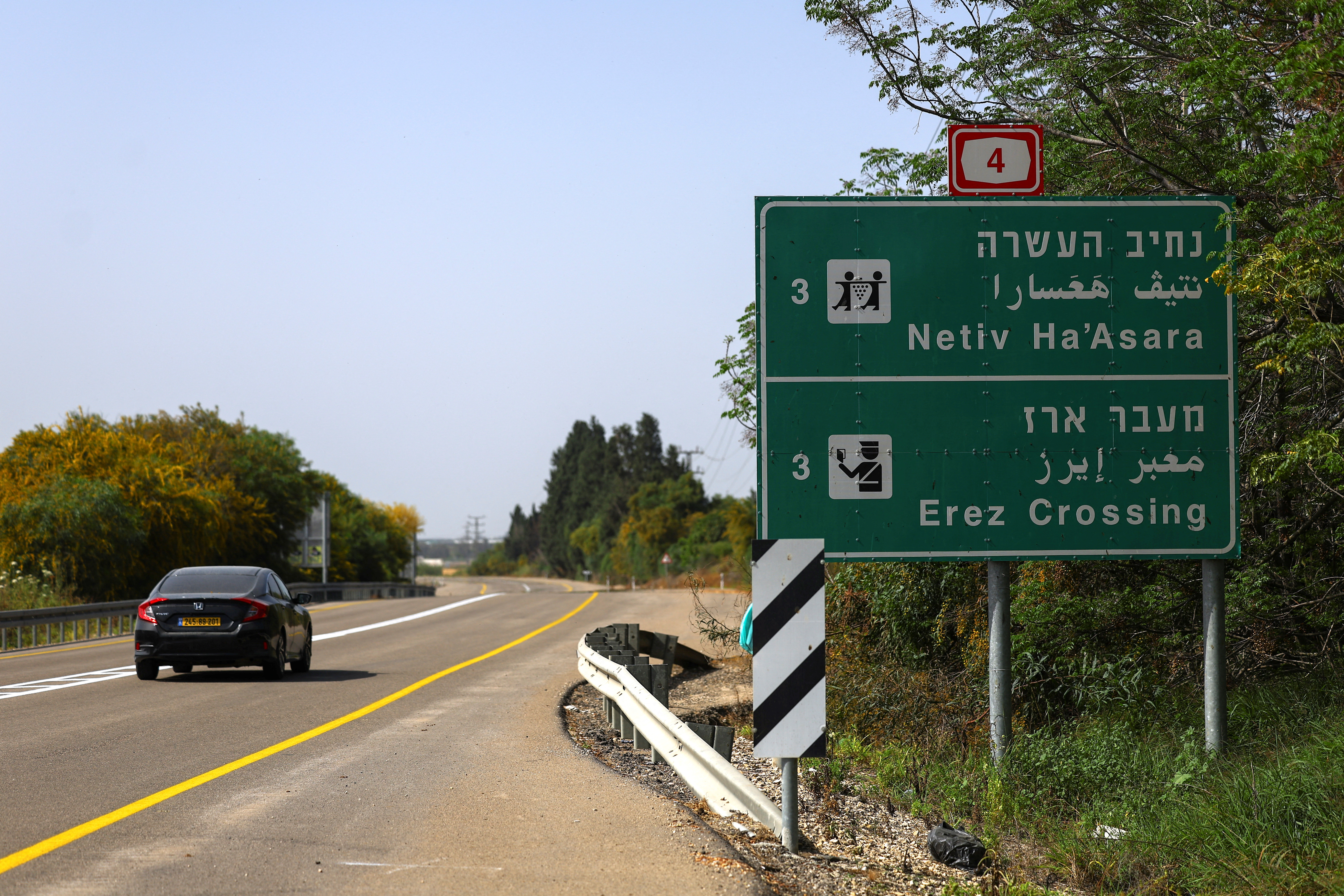 A car passes by an Erez Crossing signboard, after the Israeli cabinet approved the reopening of the crossing into northern Gaza
