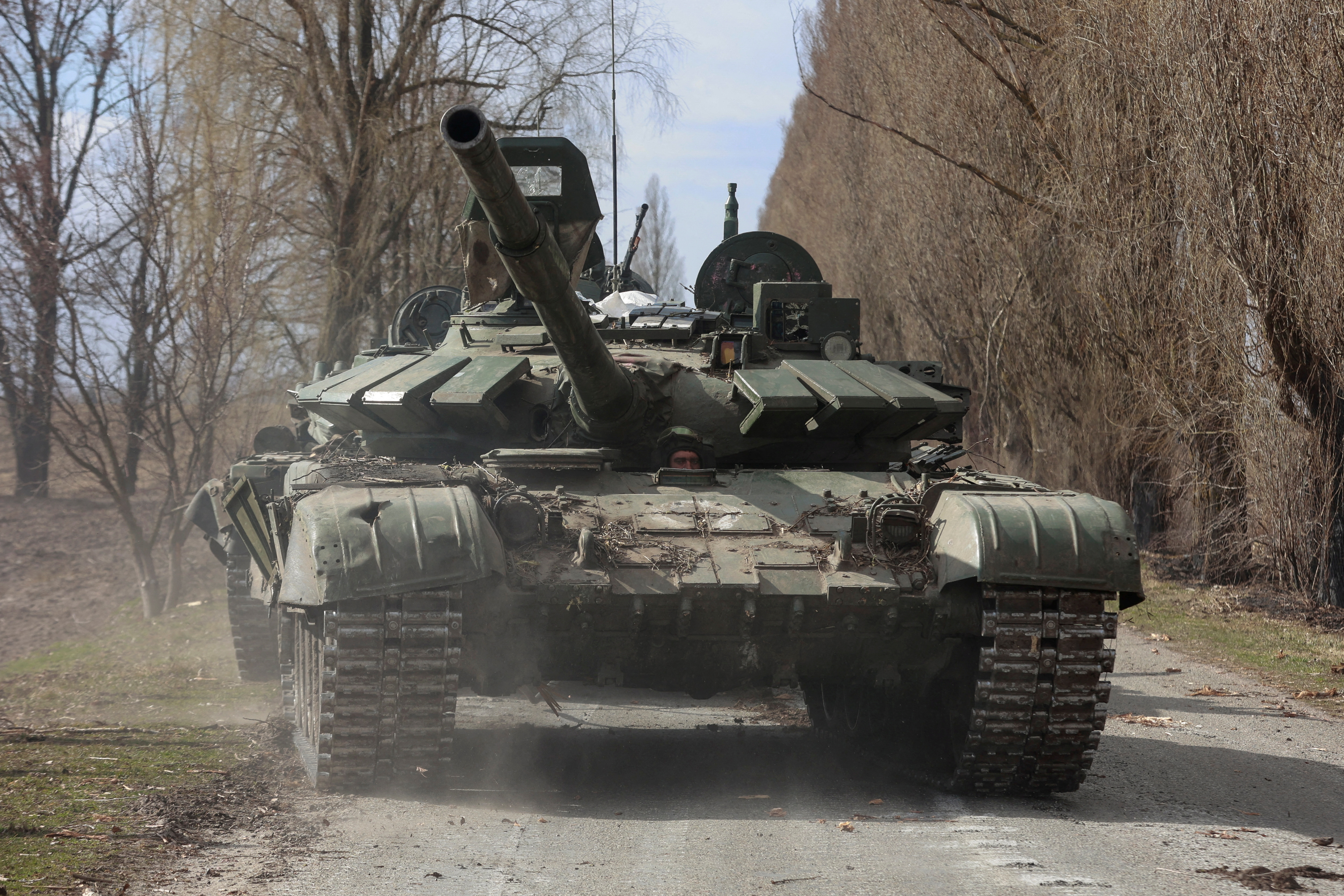 Ukrainian service member drives a captured Russian T-72 tank in Lukianivka